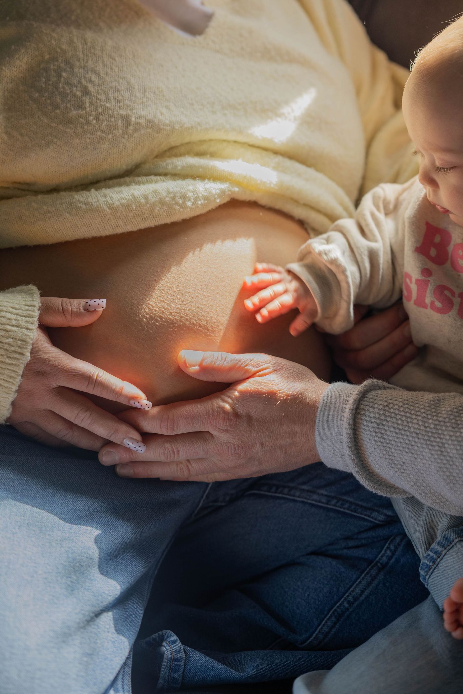 A series of close-up shots showing small hands gently touching and holding a larger hand against a light background.
