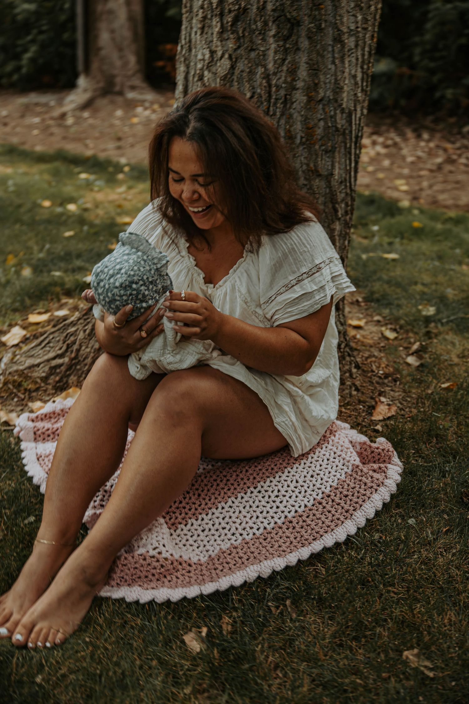 Series of outdoor photos showing someone sitting against a tree trunk wearing a polka dot dress in natural light.