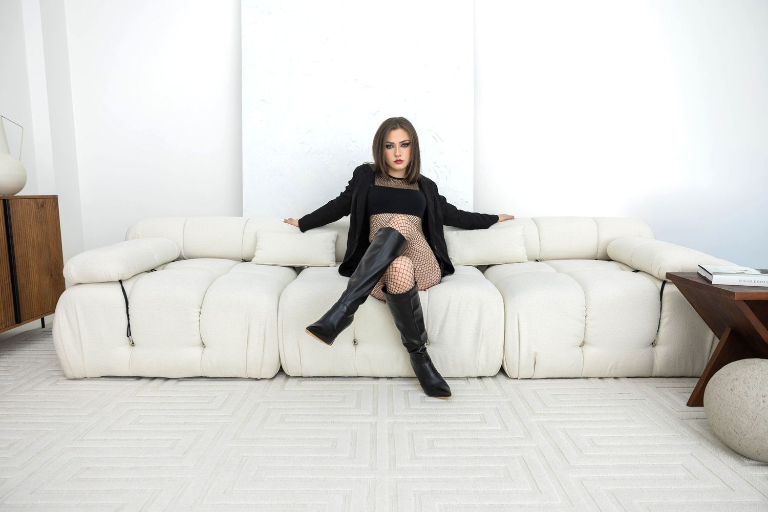 Person in stylish black dress and boots reclining across multiple photos in sequence, creating a dynamic motion effect.
