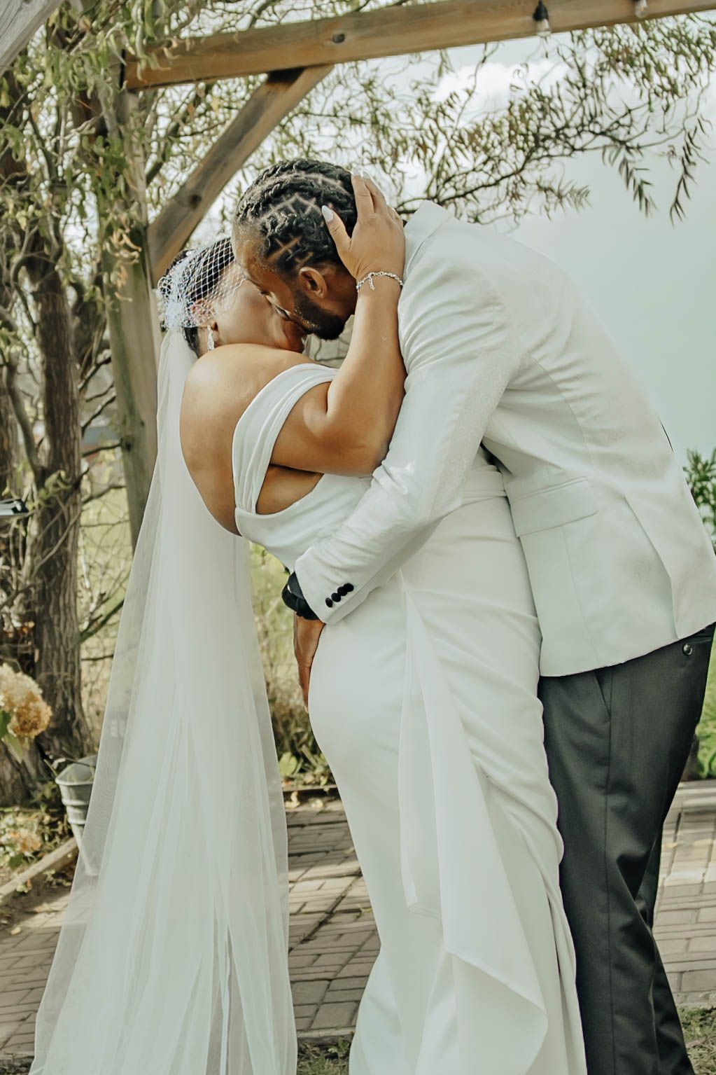 A romantic wedding moment captured in a series of four sequential photos showing a tender embrace under trees.