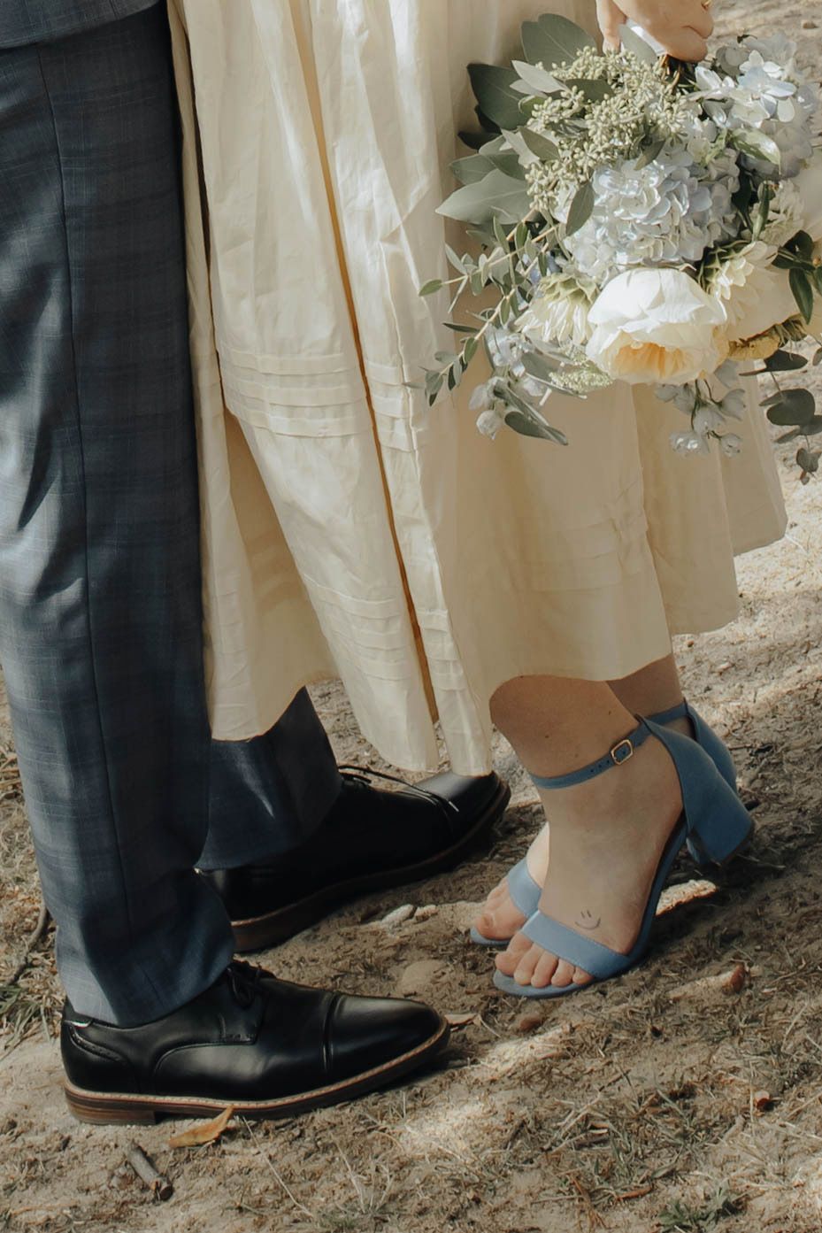 Wedding party shows close-up of dress shoes and heels standing together in elegant formal footwear lineup.