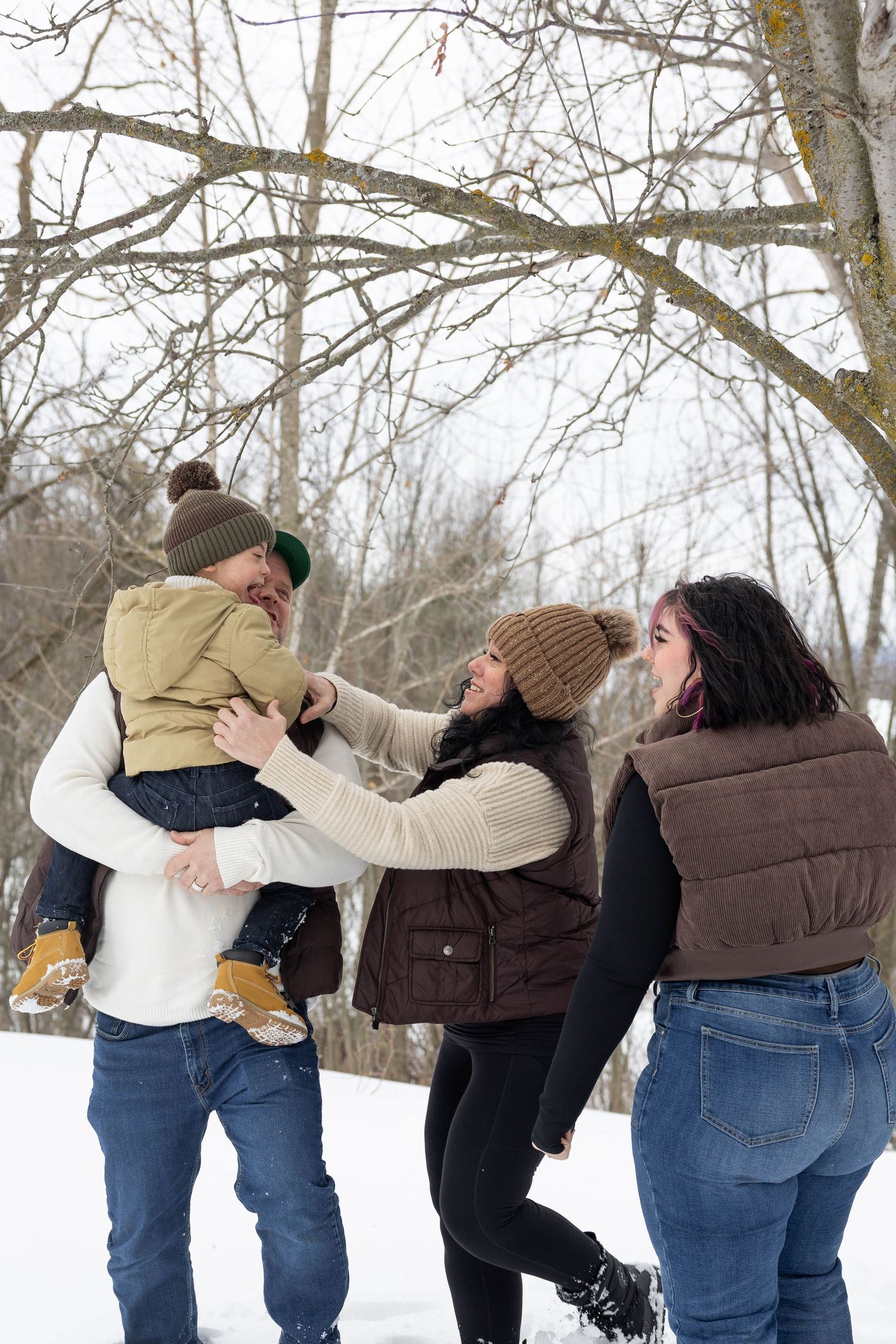 A playful sequence of a couple dancing and embracing in a snowy winter landscape with bare trees.