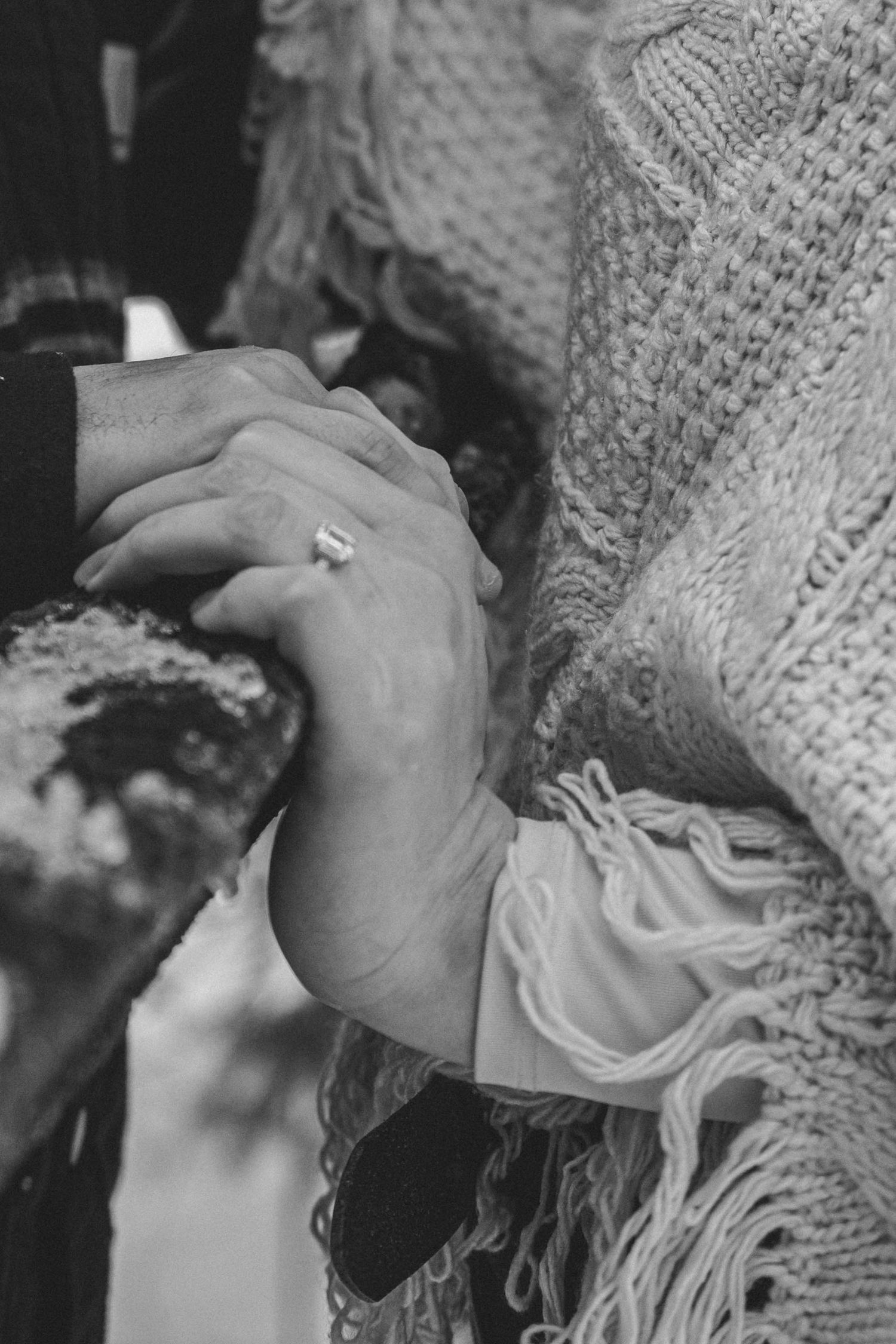 A series of black and white close-up photos showing hands wearing a knitted sweater or gloves.