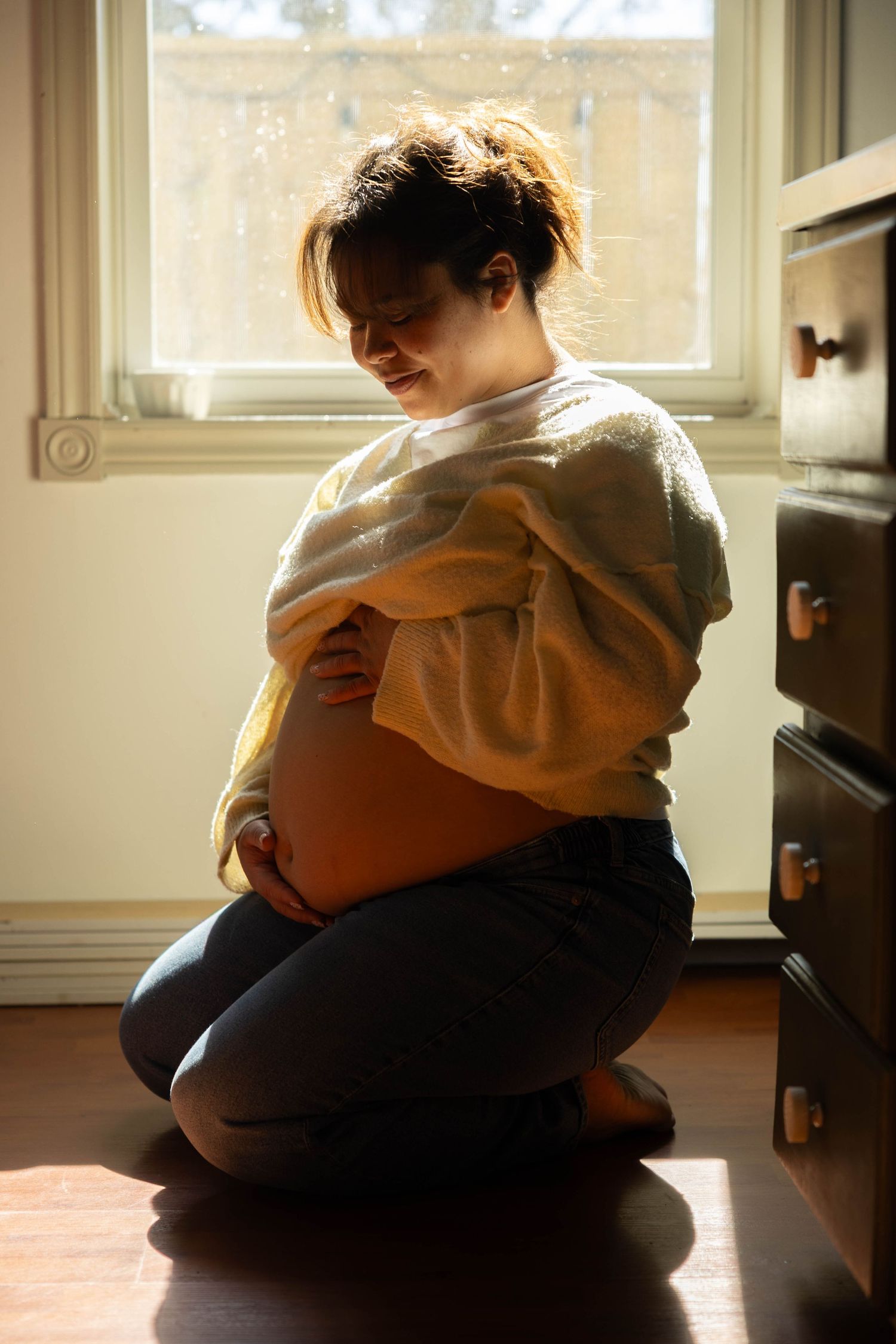 A series of intimate silhouettes showing two people embracing in warm window light on a carpeted floor.