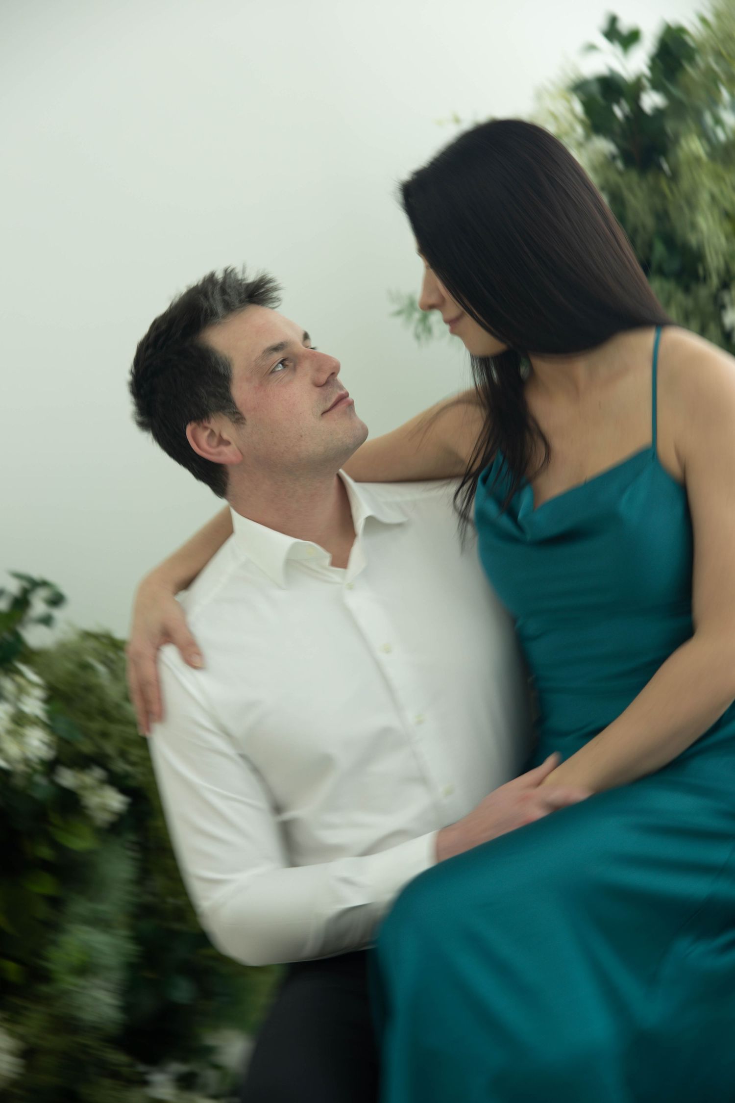 A romantic couple in white shirt and teal dress embrace while dancing outdoors in a series of motion shots.
