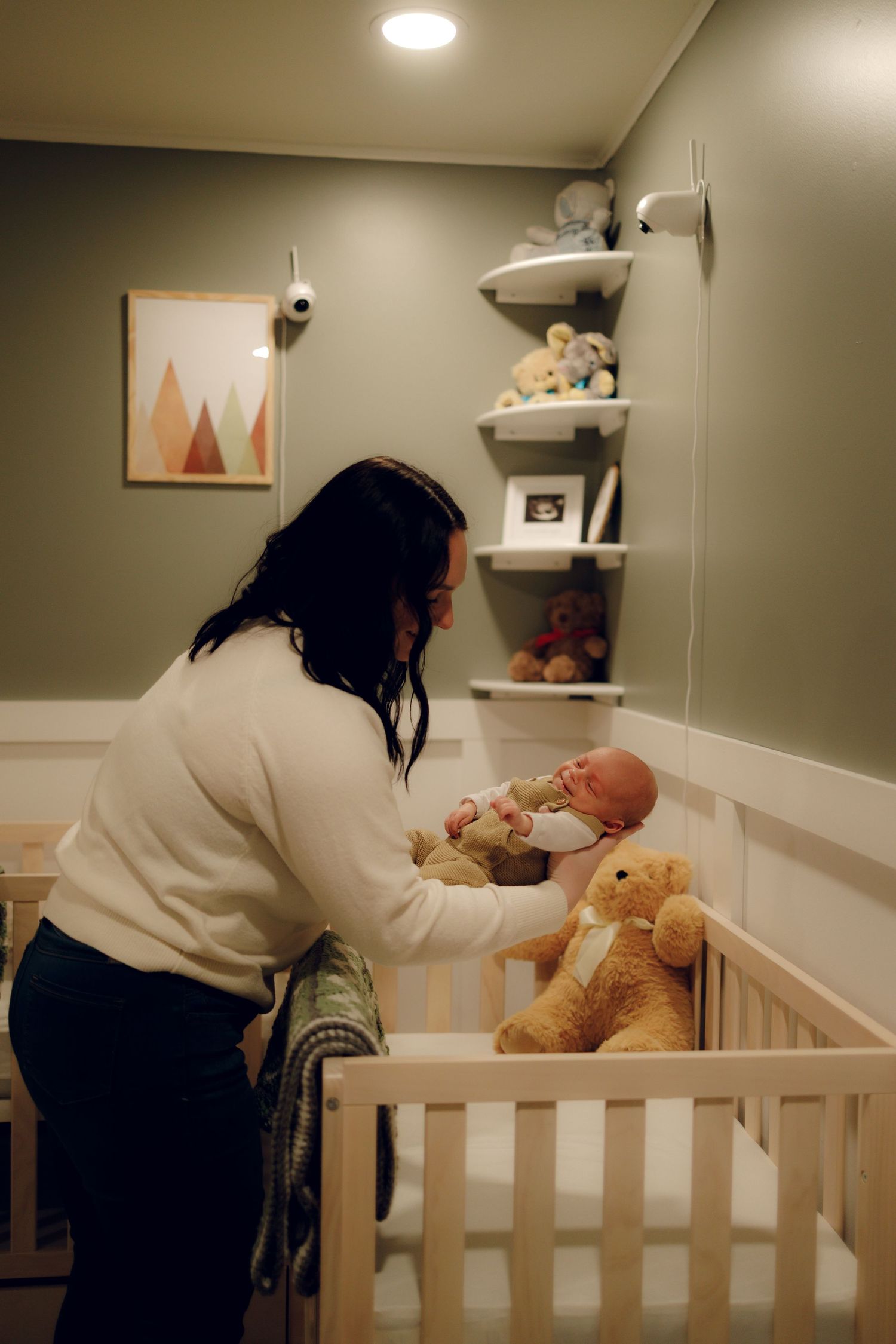 A sequence of nurturing moments shows a caregiver tending to a baby in a white wooden crib at nighttime.