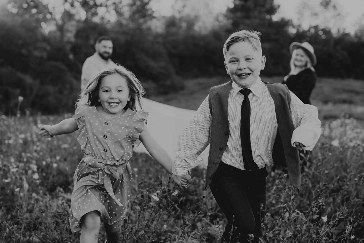A series of black and white photographs showing joyful moments of people laughing and embracing in outdoor settings.