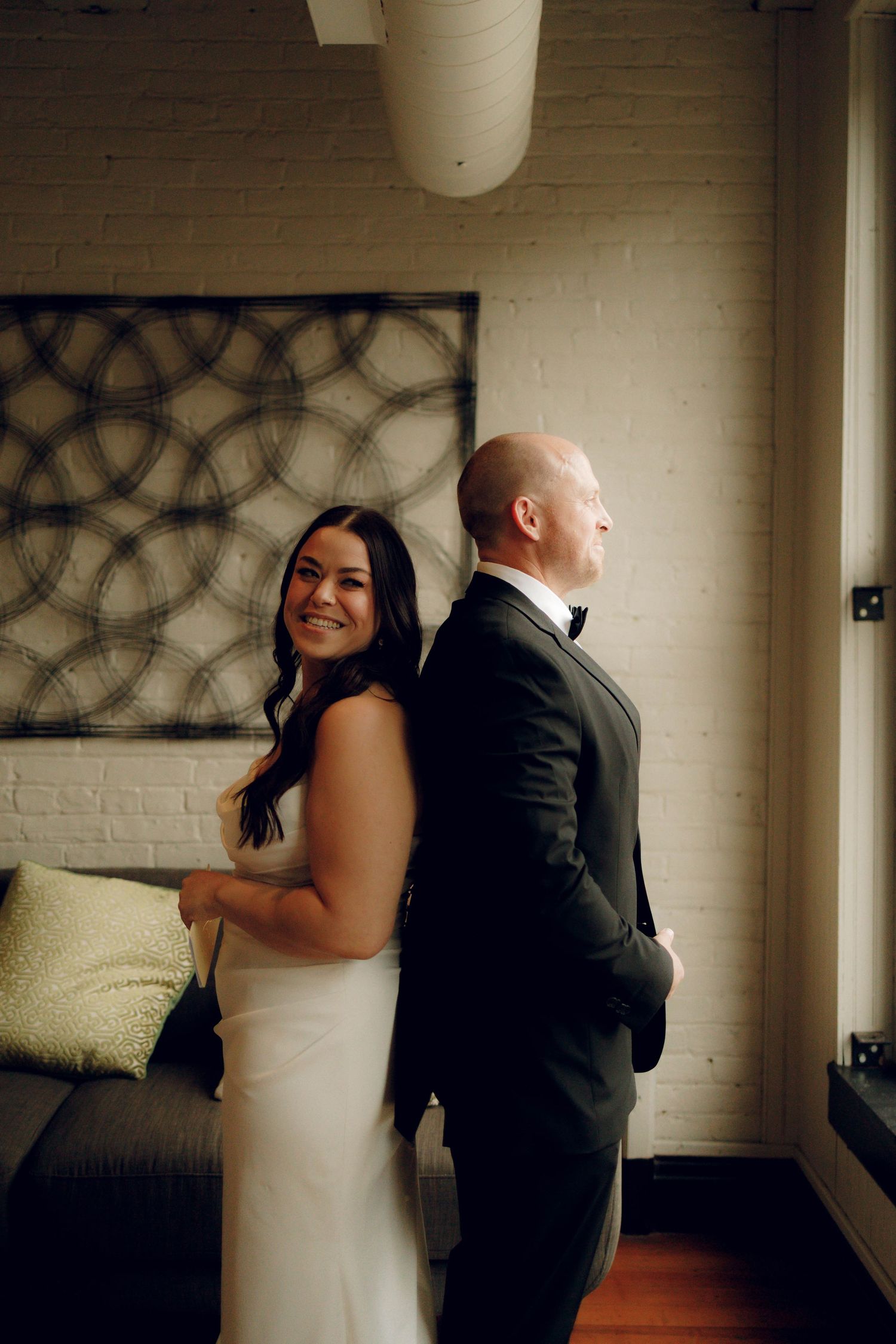 A romantic first look moment between a bride in white and groom in black during their wedding celebration.
