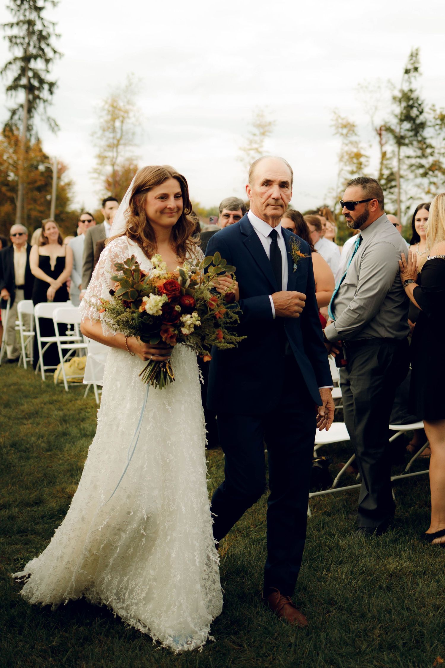A wedding celebration on a grassy lawn with guests mingling during golden hour.