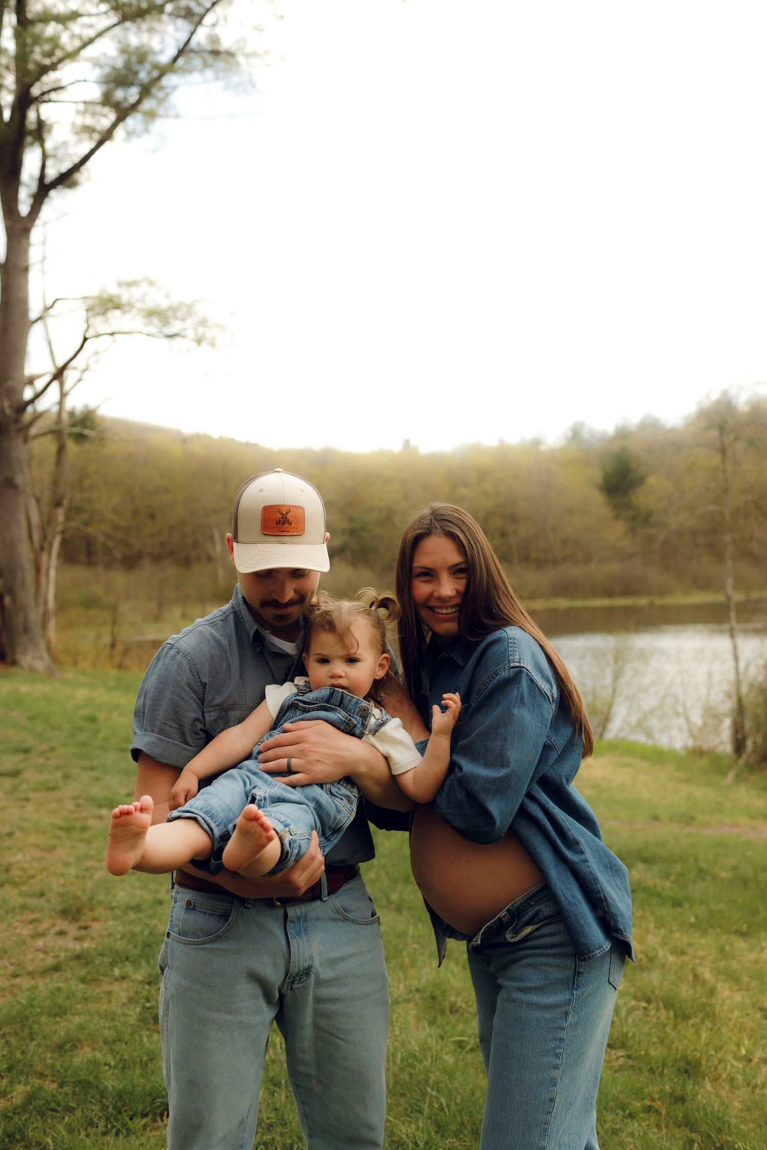 A family enjoys a casual moment together outdoors by a lake on a spring afternoon.