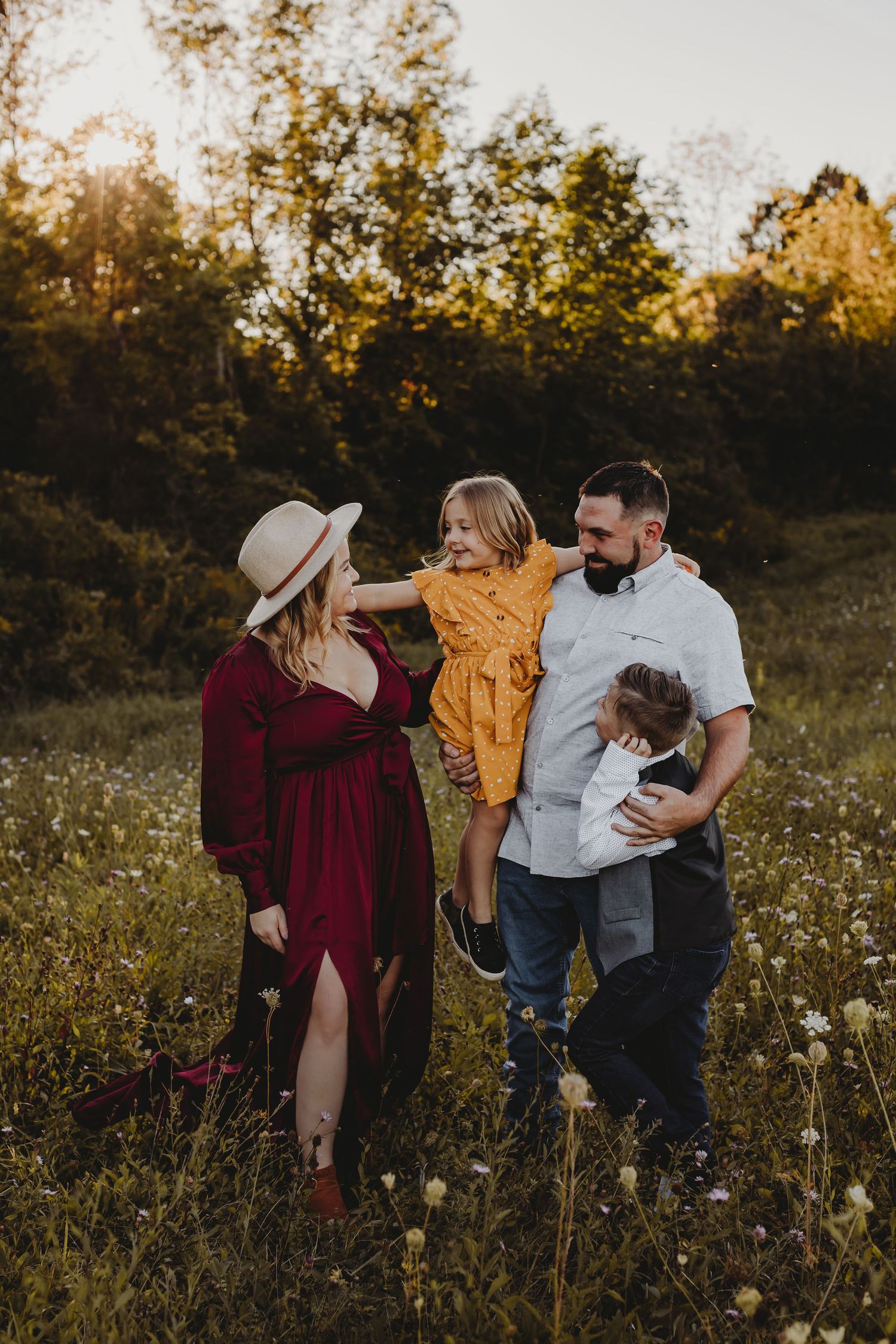 Family sharing joyful moments together in a golden sunlit wildflower meadow at sunset.