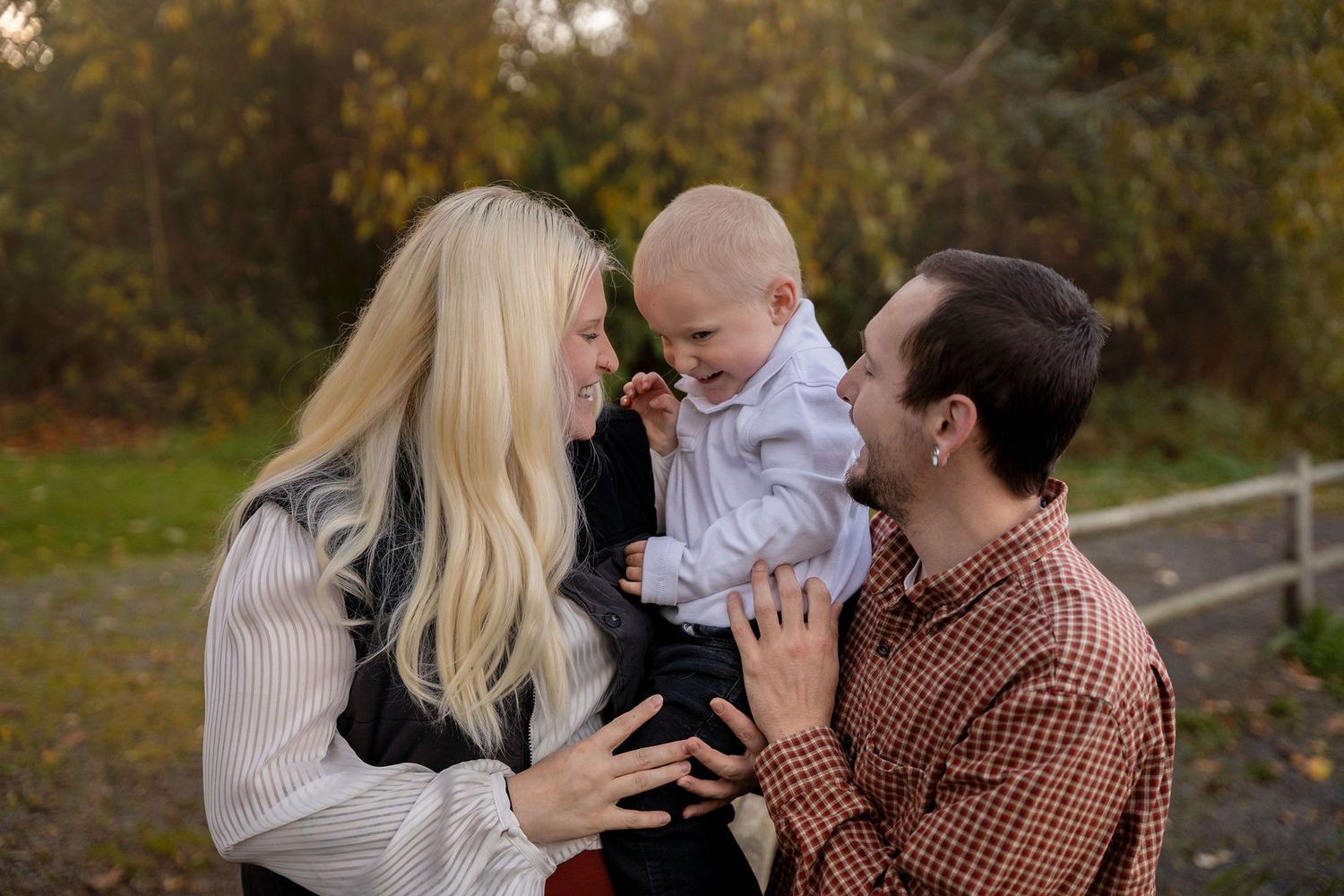 A family shares tender moments together outdoors during an autumn photo session in nature.