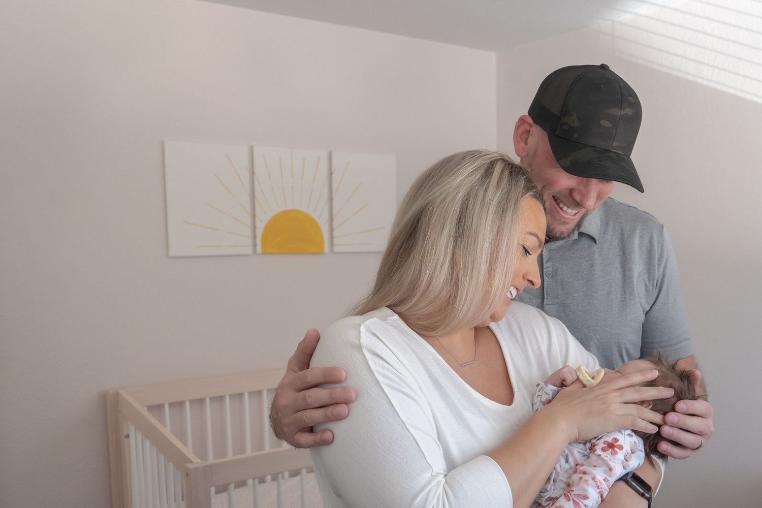 A tender nursery moment with a couple admiring something together near a crib.