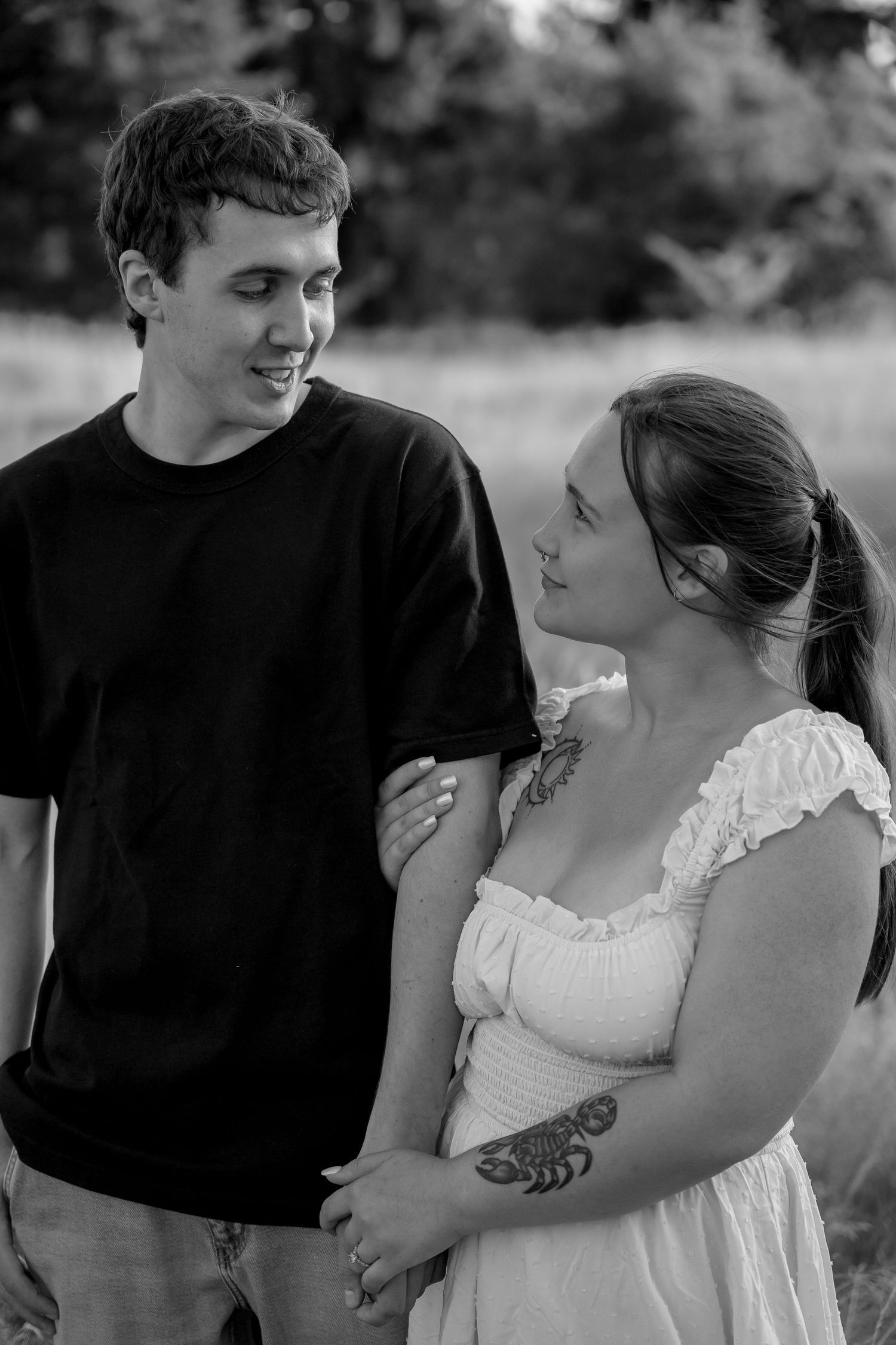 A romantic black and white photo series showing a couple embracing and sharing tender moments in an outdoor setting.