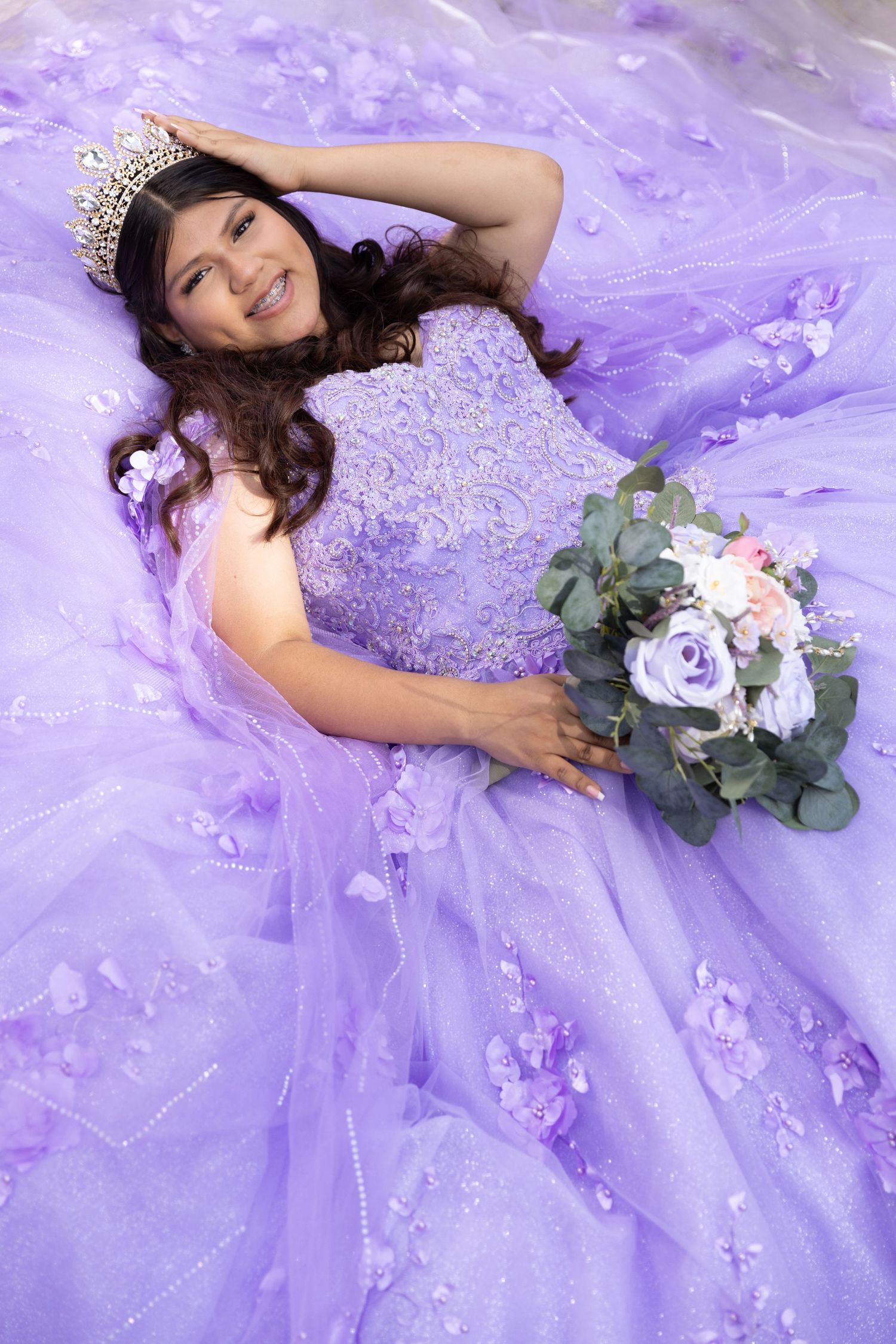 Elegant purple ballgown with floral details captured in dreamy lavender-tinted photoshoot.
