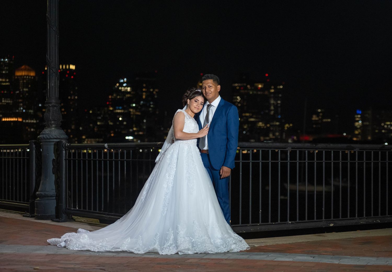 Elegant nighttime wedding photography with city lights creating romantic ambiance.