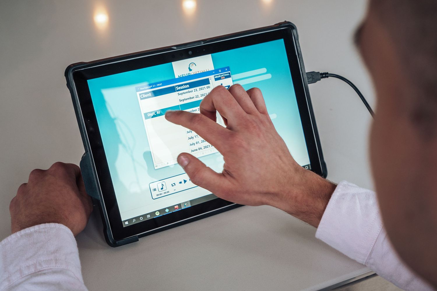 A person using a tablet device to interact with a digital interface in an office environment.