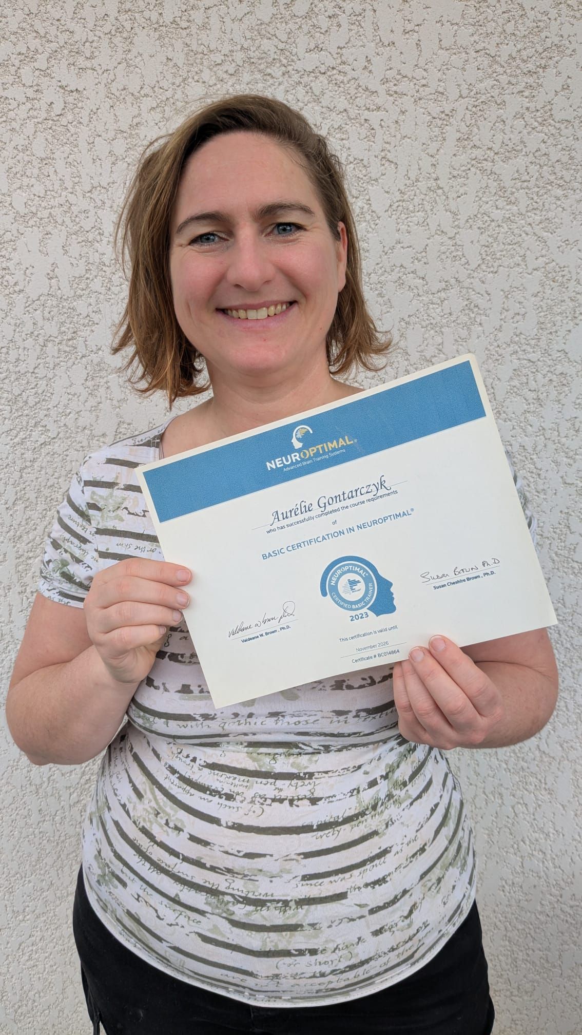 Four photo series showing someone in a white patterned shirt progressively displaying a blue and white certificate.