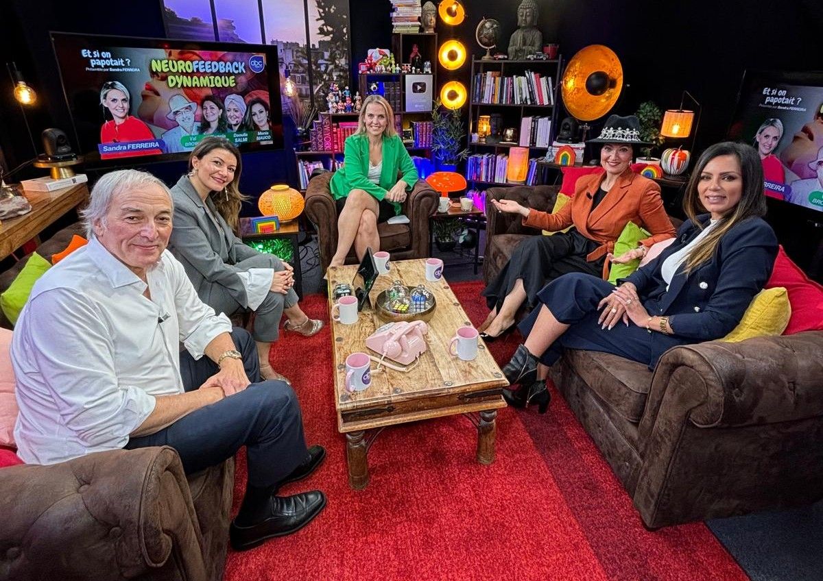 Group of people relaxing and socializing on comfortable red carpet during an indoor gathering.