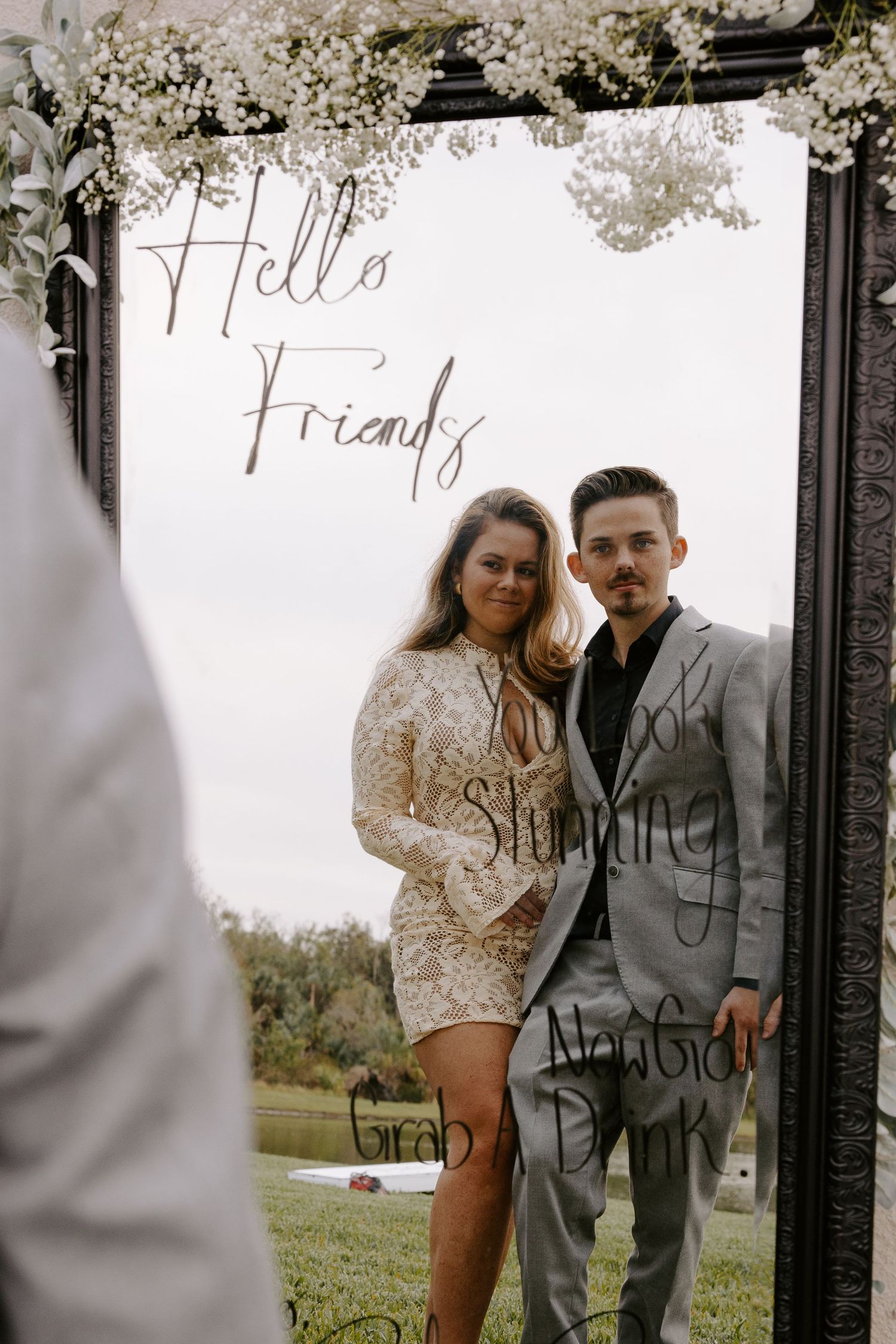 Stylish engagement photo session against decorative black frame outdoors.