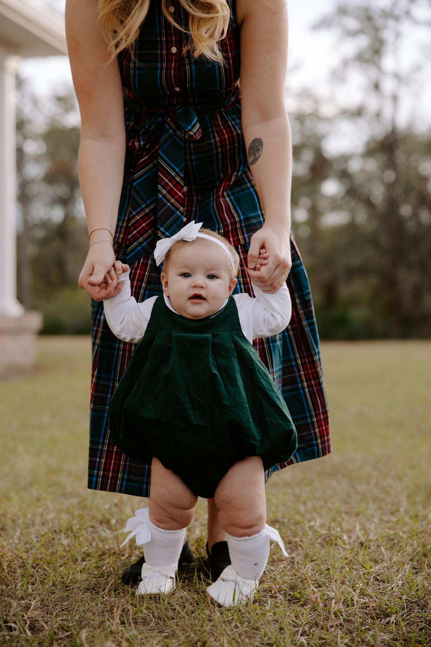 Close-up series showing small baby feet in white socks with plaid dress details.