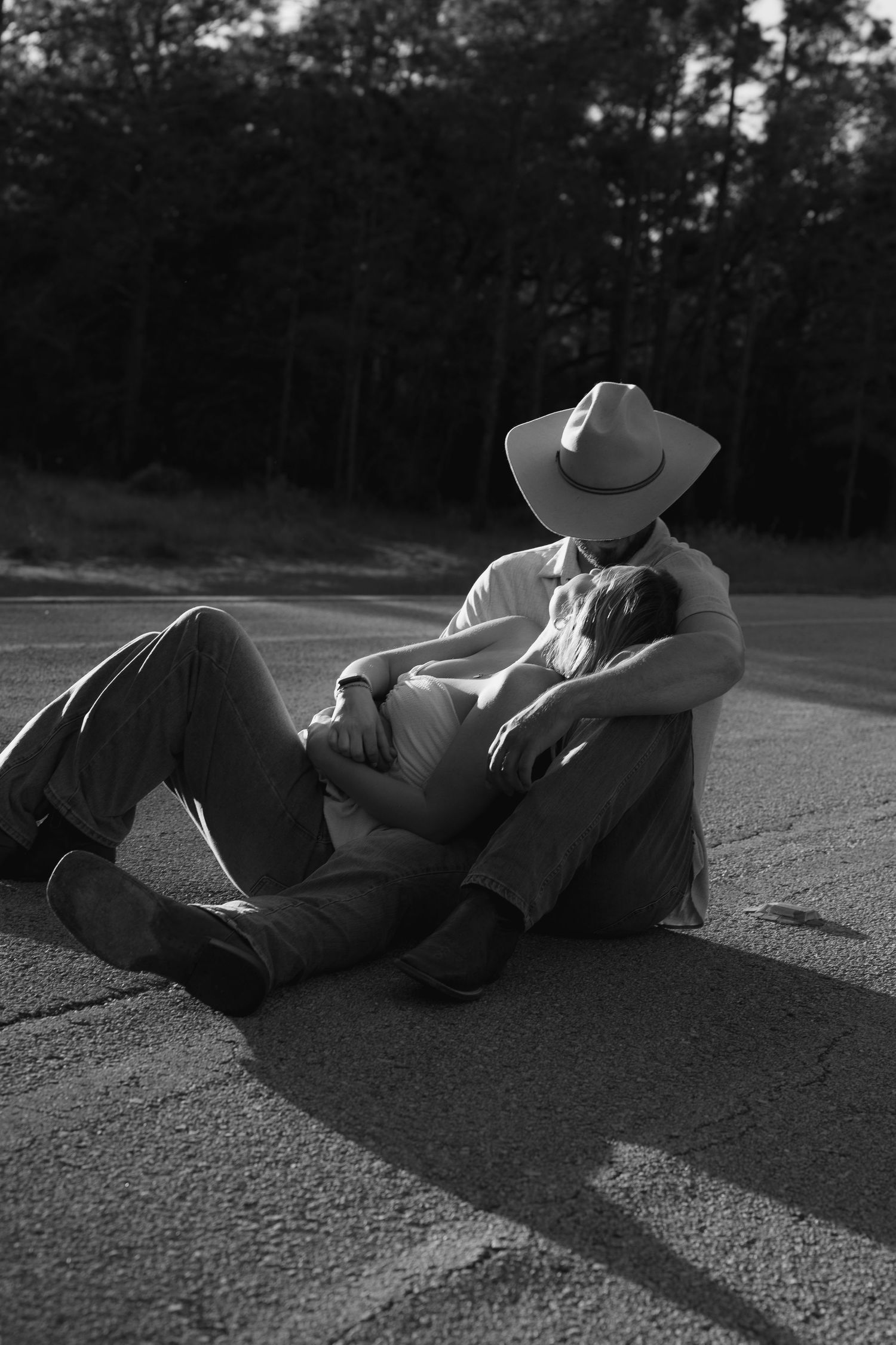 Black and white photo sequence showing two people lying on pavement casting long shadows at sunset.