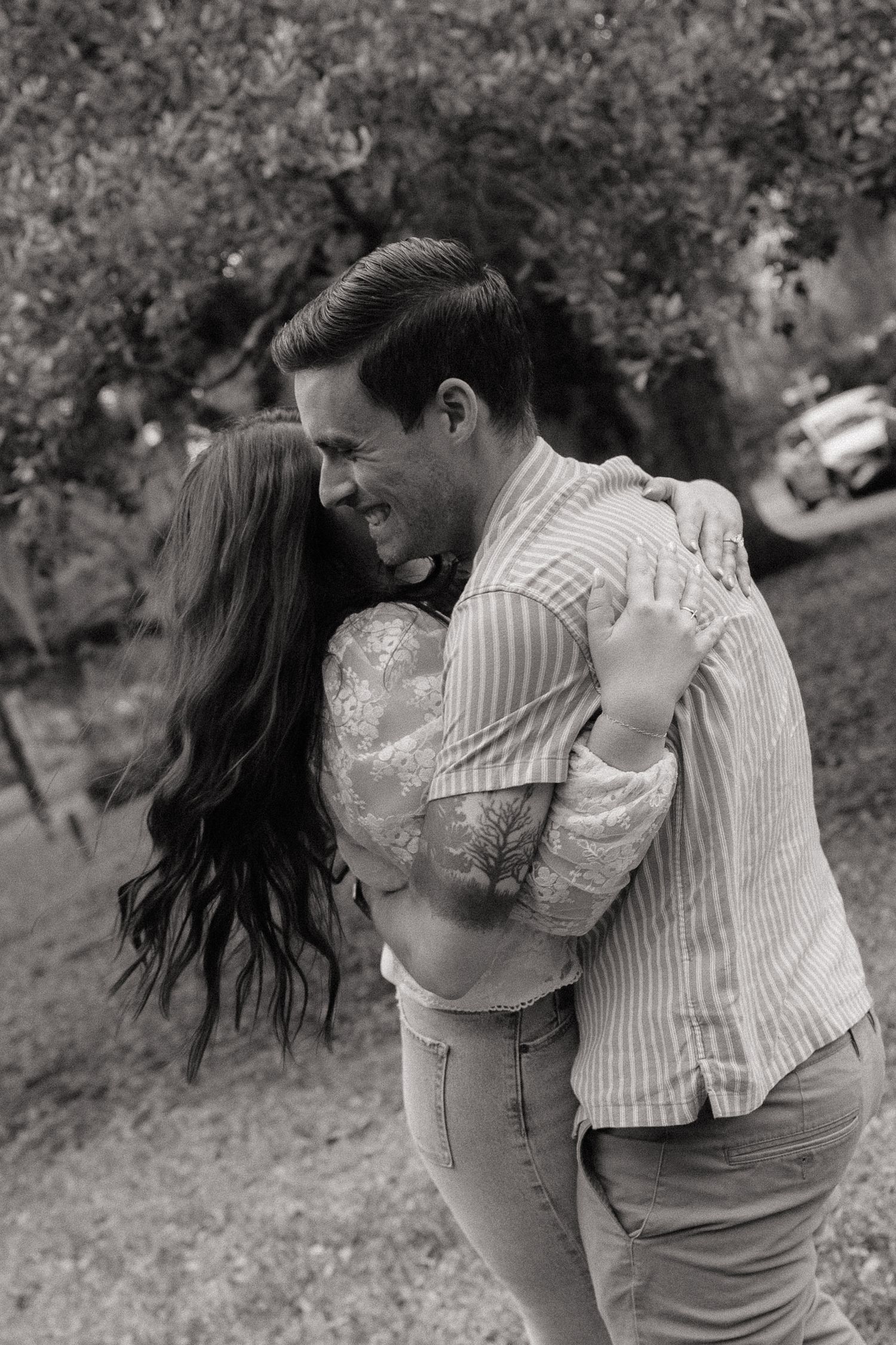 A romantic black and white sequence shows a couple embracing and dancing together outdoors in a natural setting.