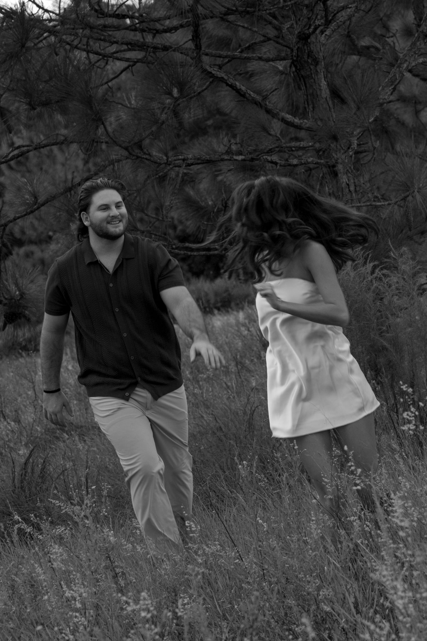 A grayscale sequence of outdoor portraits showing a person sitting in tall grass beneath tree branches.