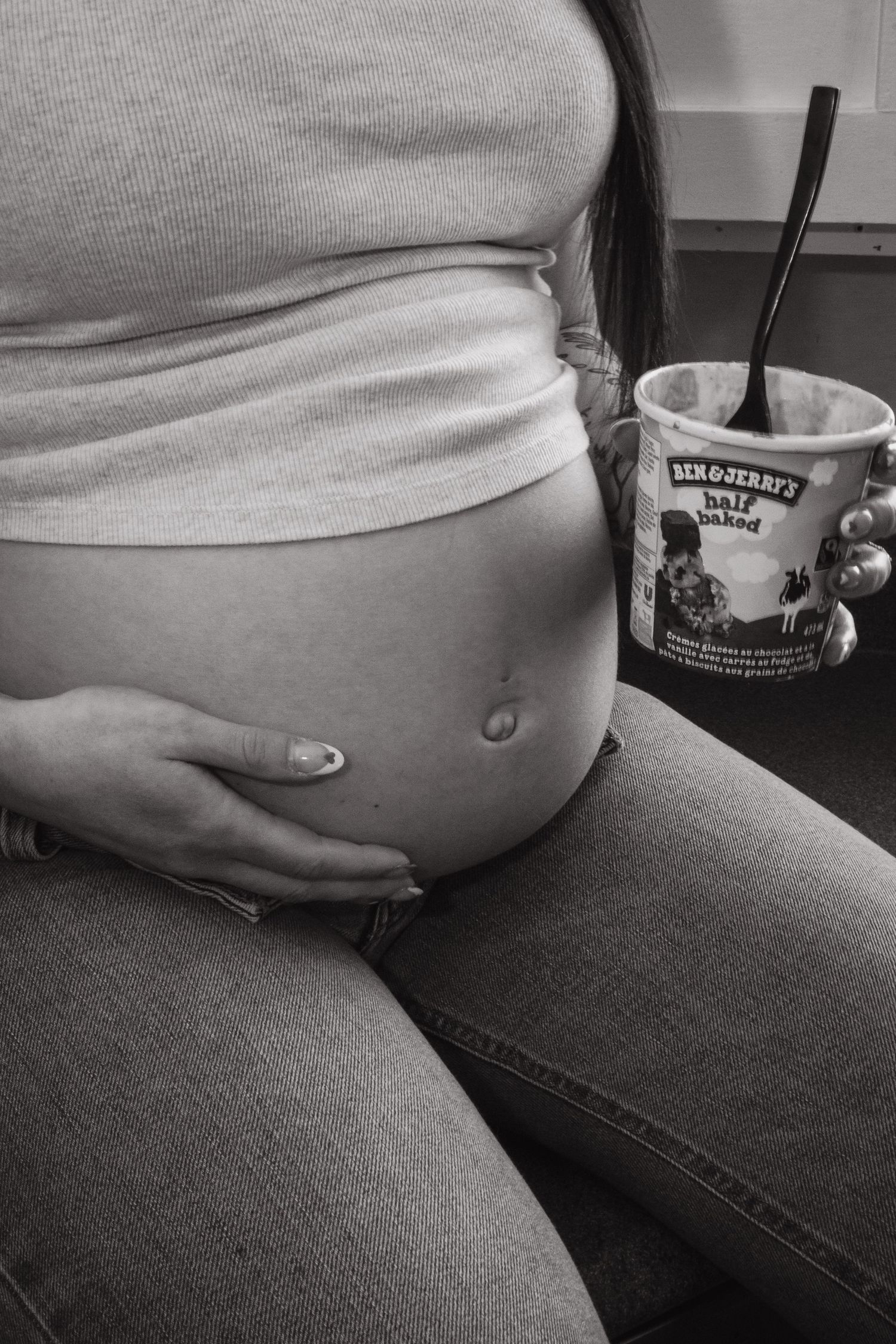 pregnant woman holding her belly and holding ben and jerry's 