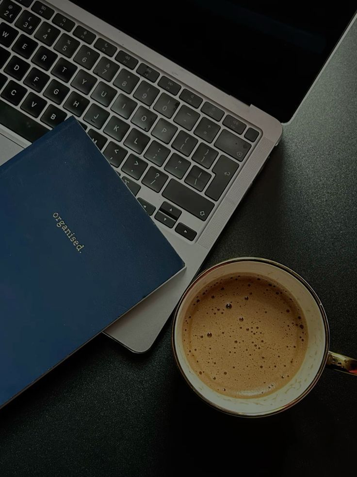 Laptop with blue notebook and latte