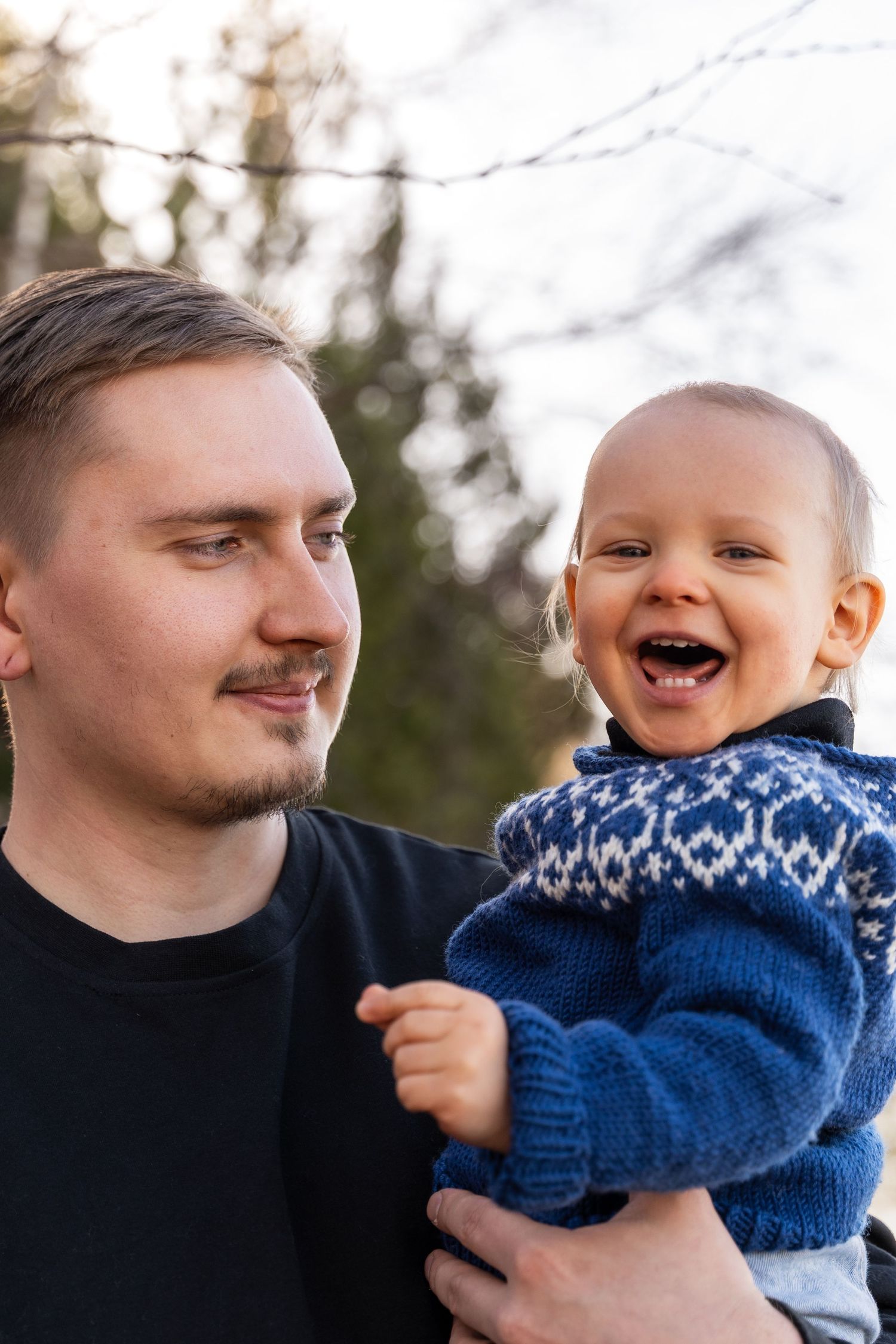 Isä ja poika sylissä.