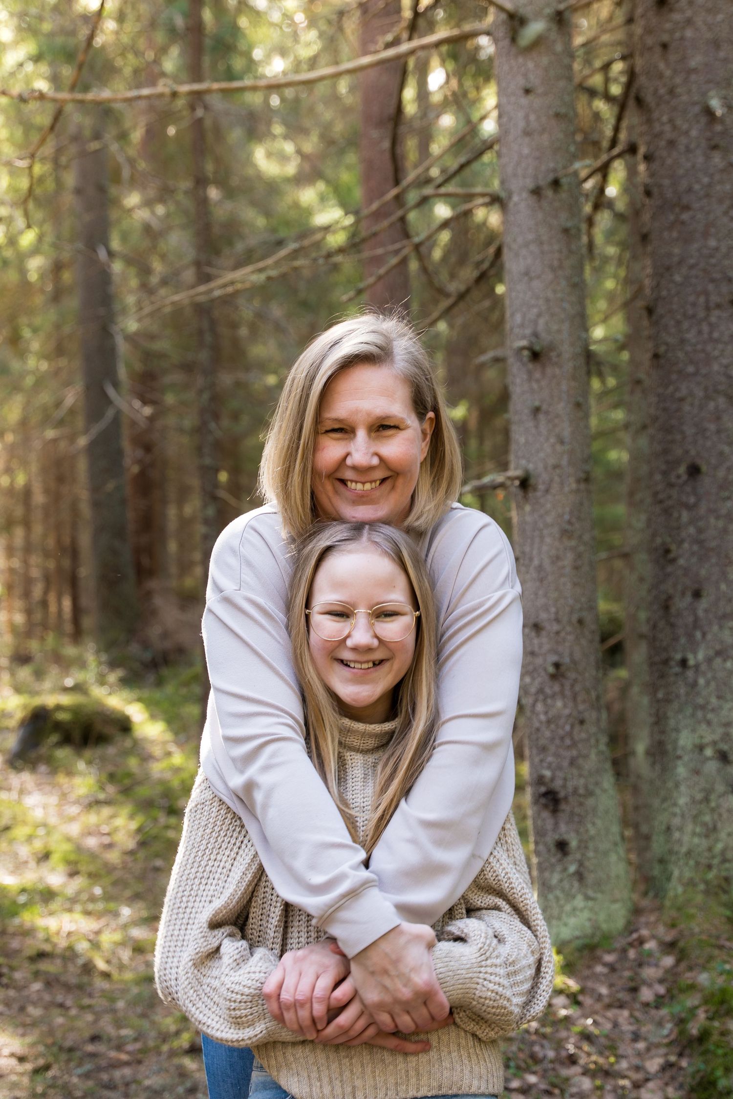 Tytär äidin syleilyssä.