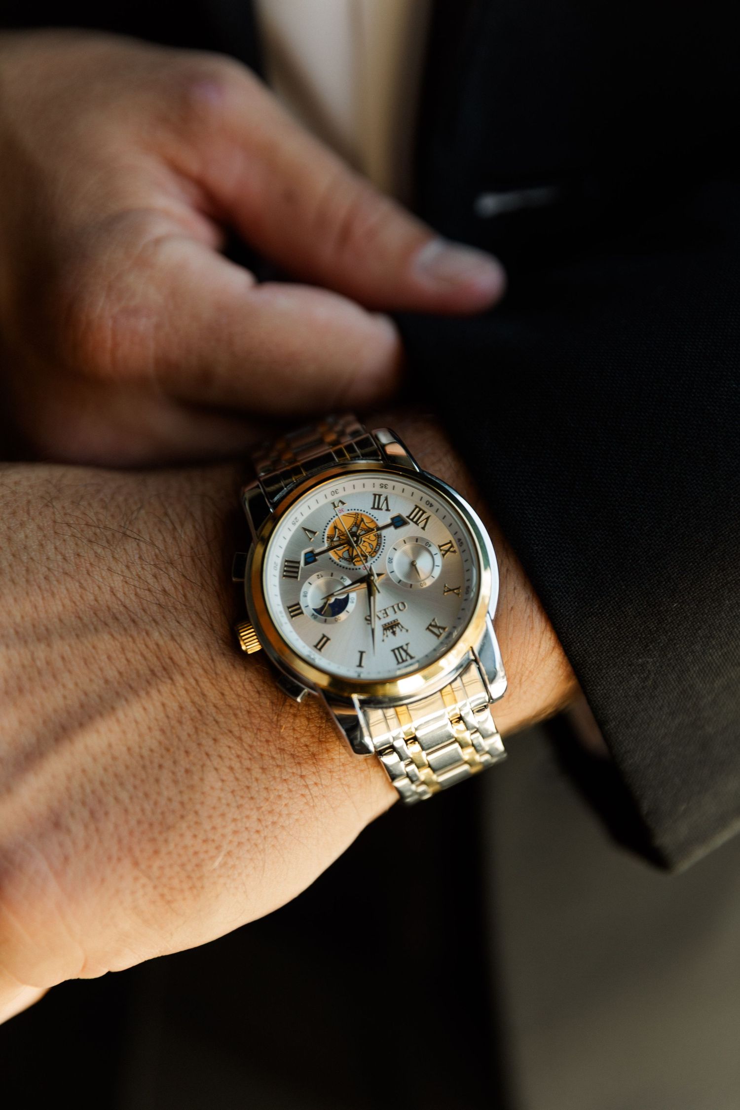 Close-up shots of an elegant silver and gold watch on someone's wrist.