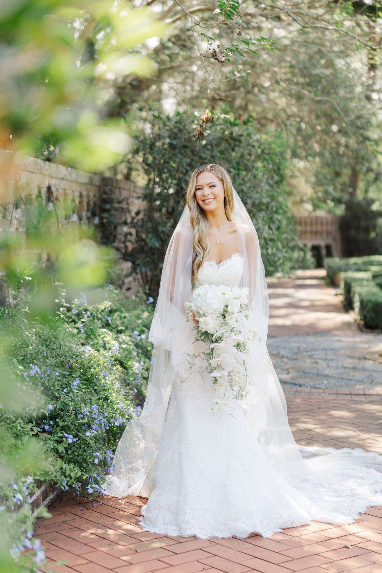 Garden bridal portraits on brick pathways surrounded by lush greenery and natural light.