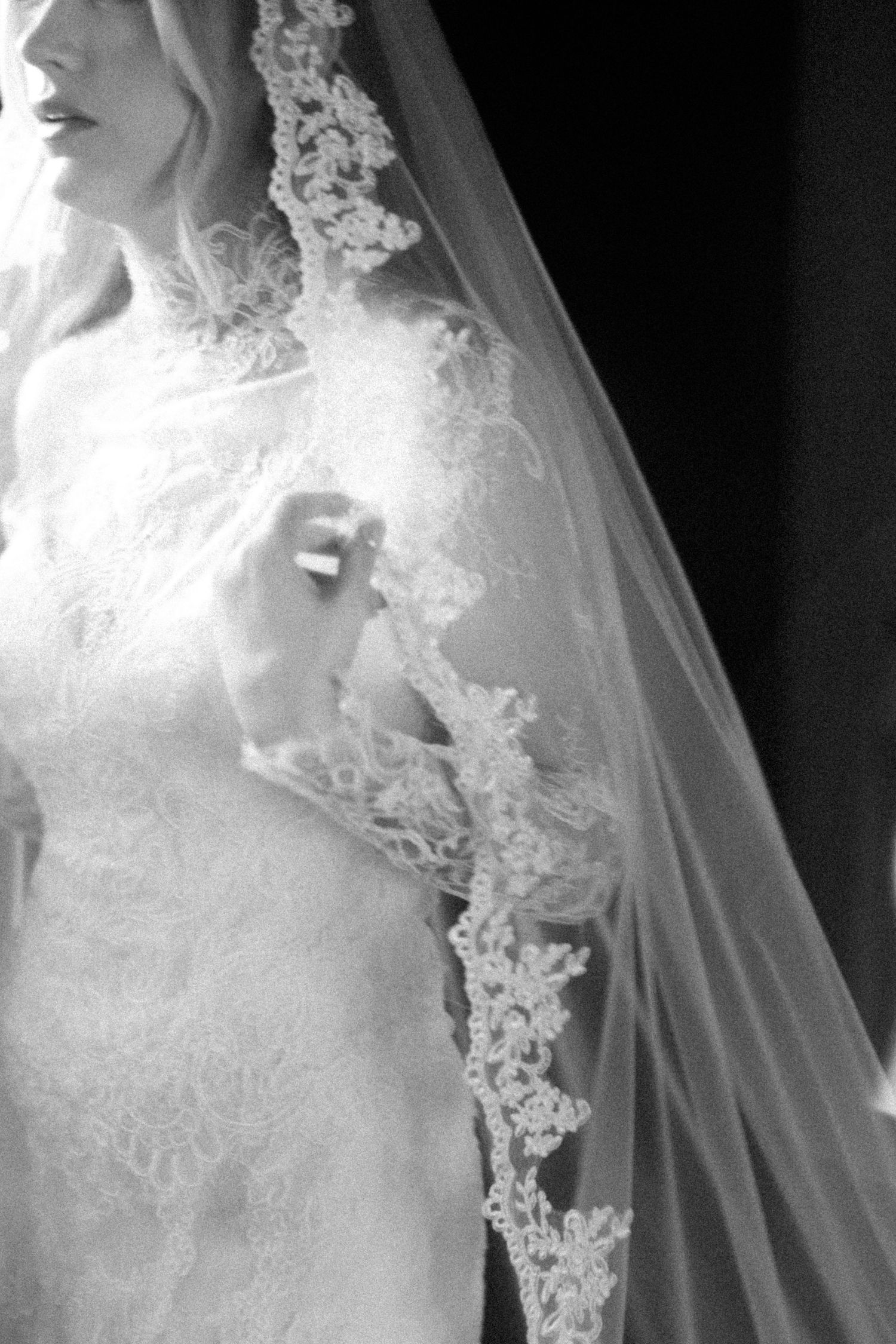 Close-up details of delicate lace appliques on a white wedding veil.