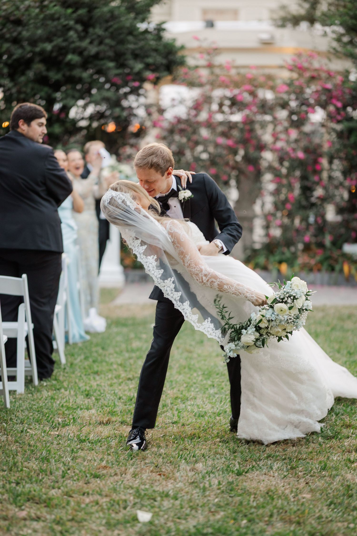 Playful sequence of wedding photos showing couple dipping and dancing on grass with flowing veil and formal attire.