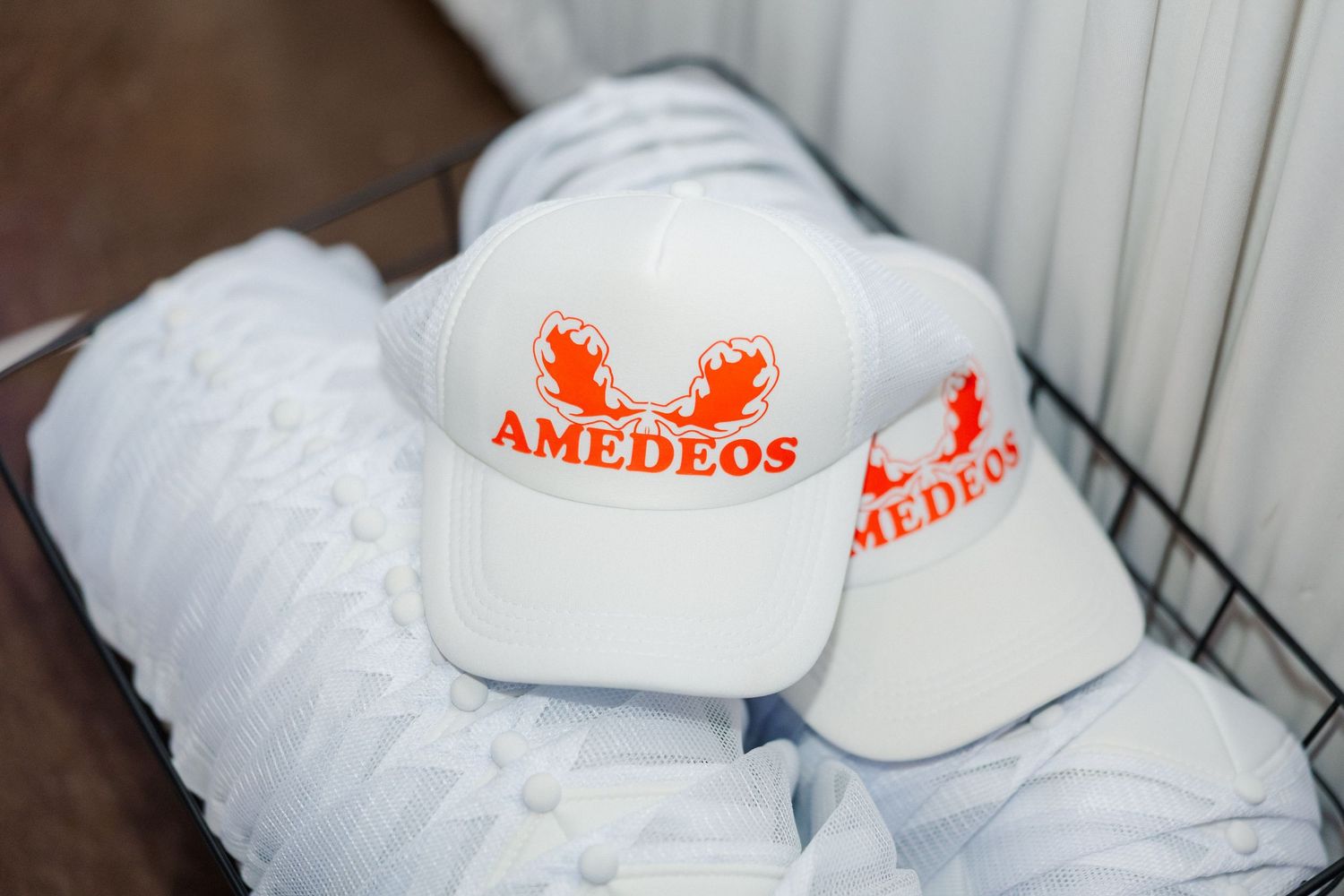 Row of white branded pillows with red Amedeos logo displayed at wedding venue.