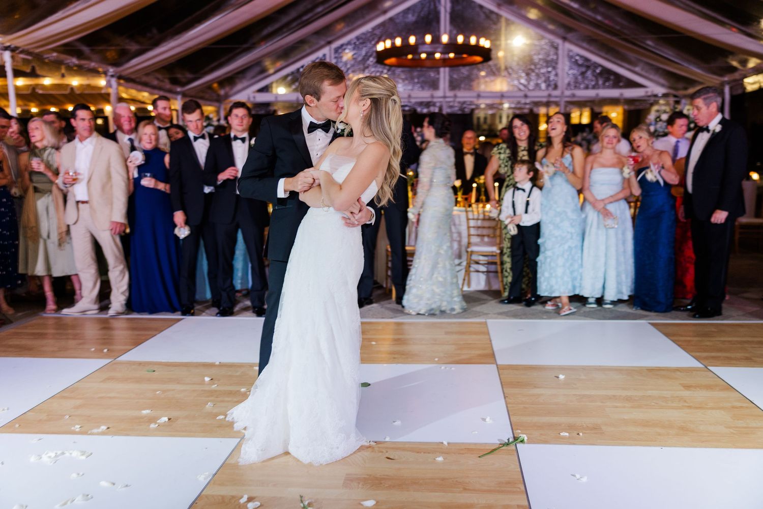 Wedding reception dance floor under a tent with guests celebrating.