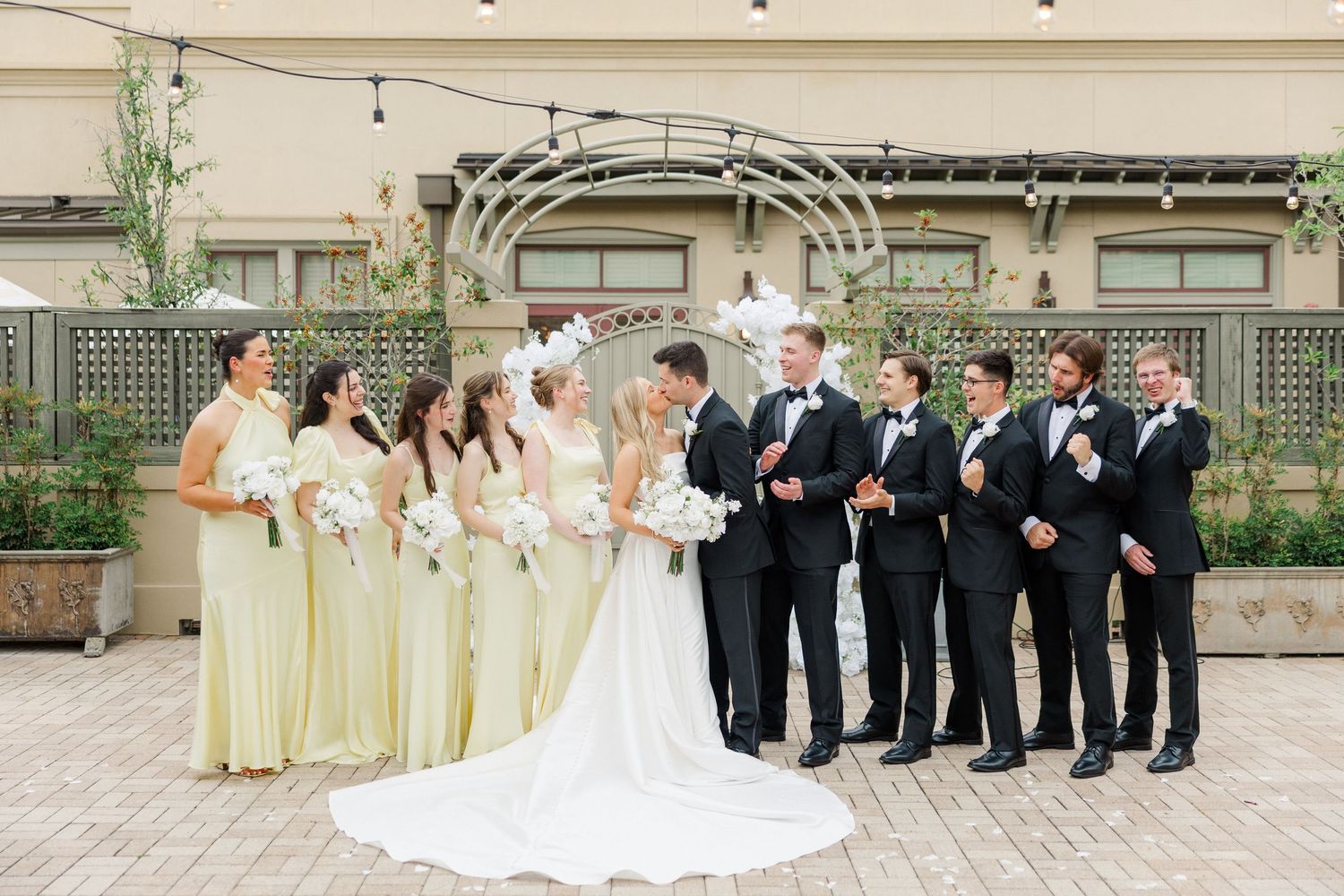 Wedding party members arranged in formal poses against modern architectural backgrounds.