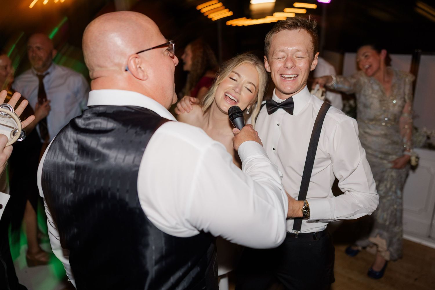Wedding guests celebrating and dancing during a lively reception party.