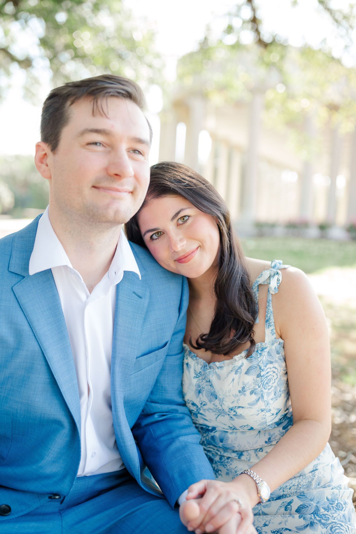 A couple in coordinating blue outfits share a tender moment during their engagement photos.