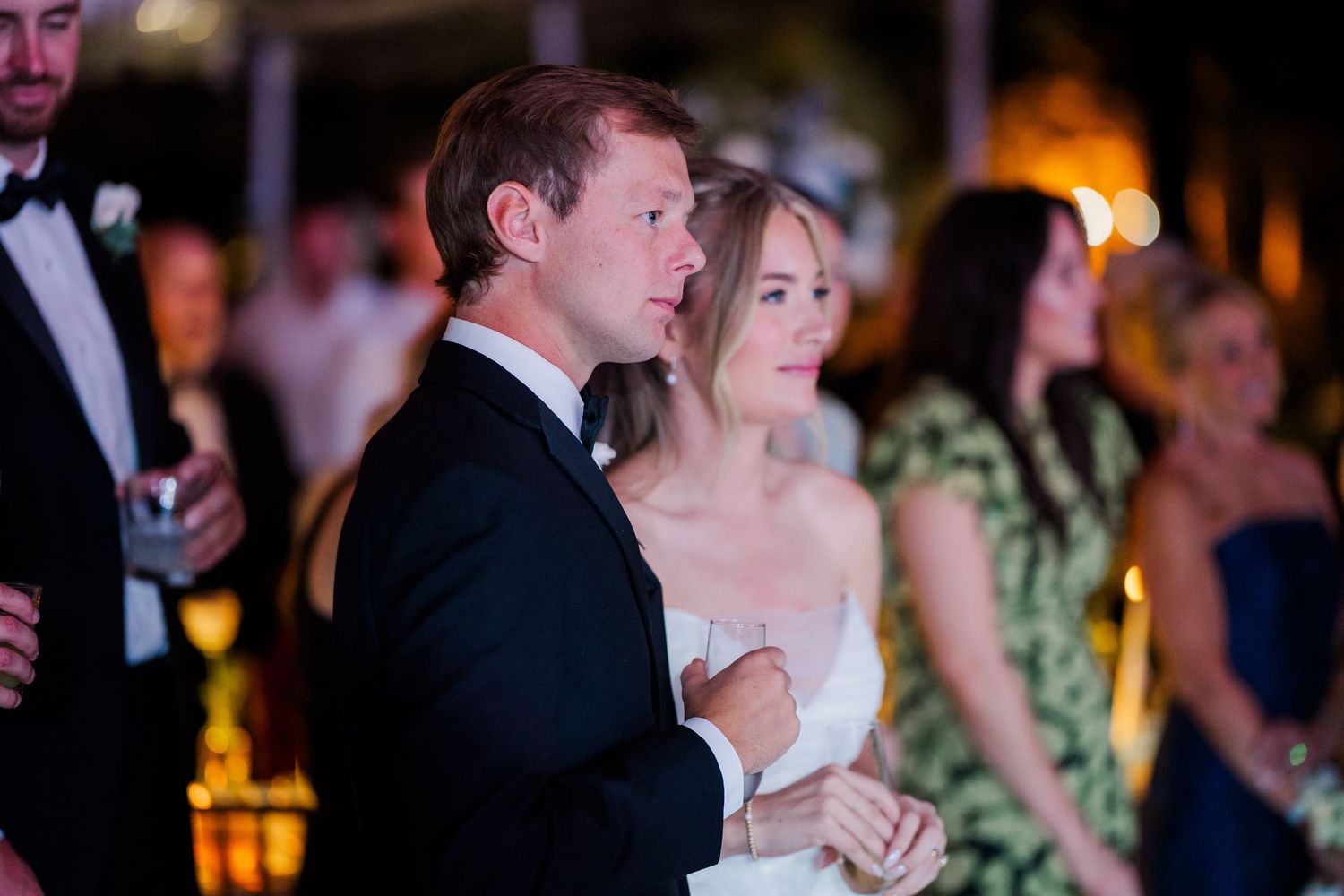 Evening wedding reception with couples dancing under warm lighting.