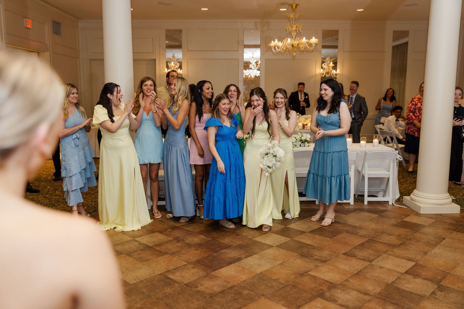 Wedding reception venue with elegant columns and tables set with blue and yellow color scheme.