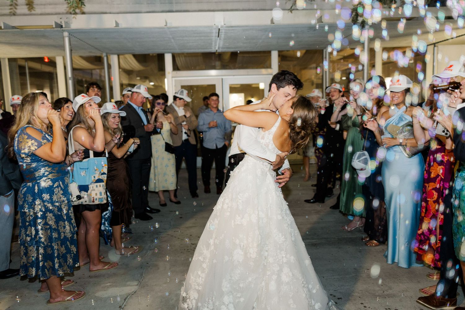 Wedding exit with guests creating bubble sendoff for the newlyweds.