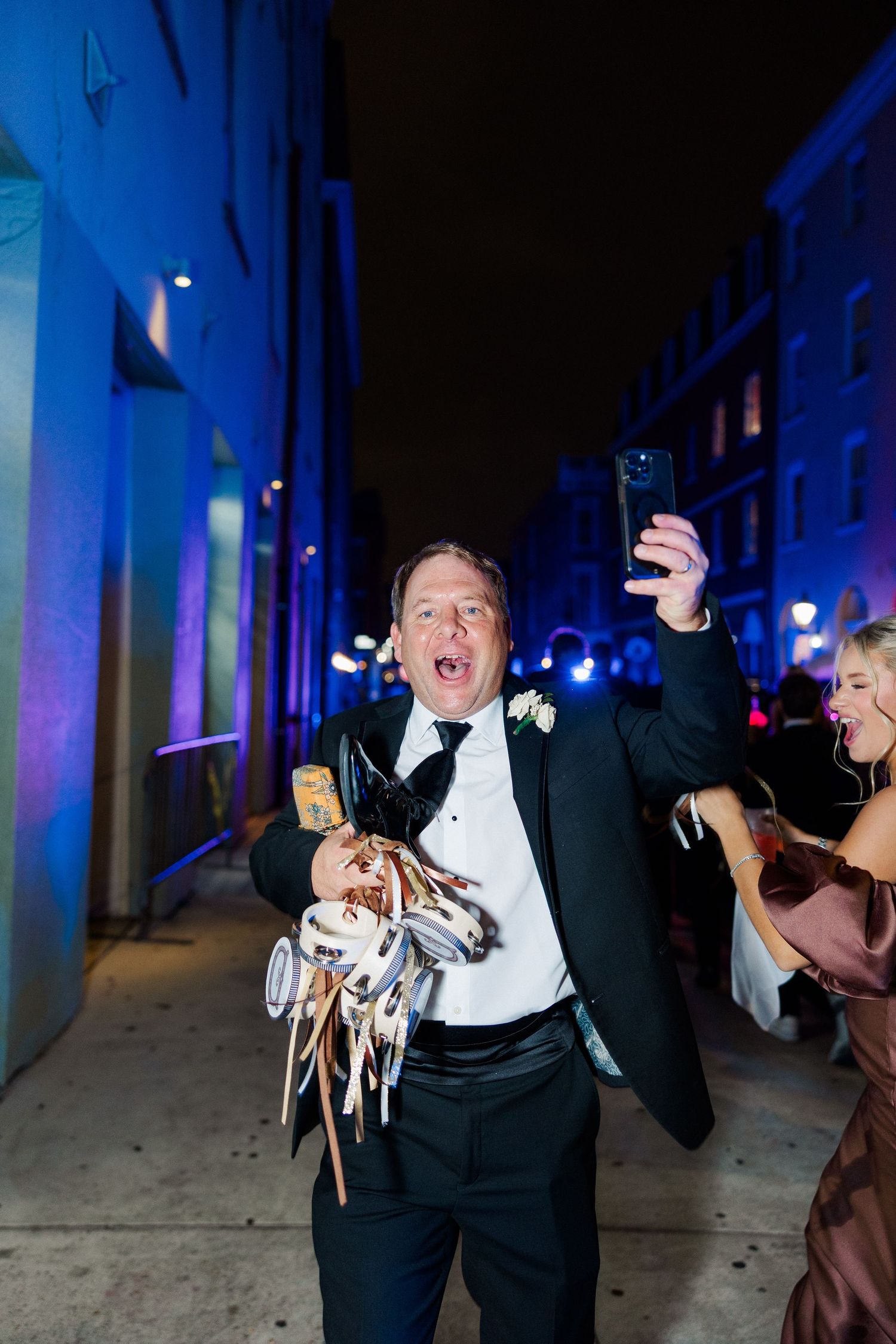 Wedding celebration at night with blue lighting and festive dancing.