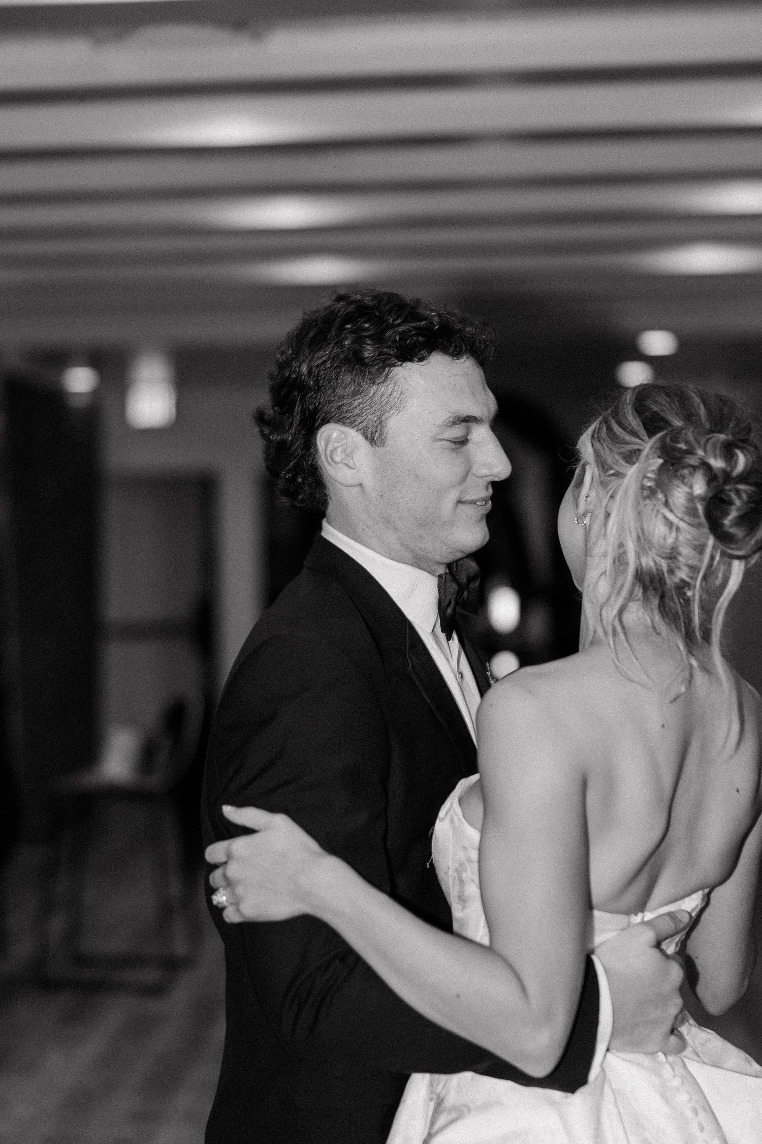 Black and white photo of a couple's intimate dance moment at their wedding reception.