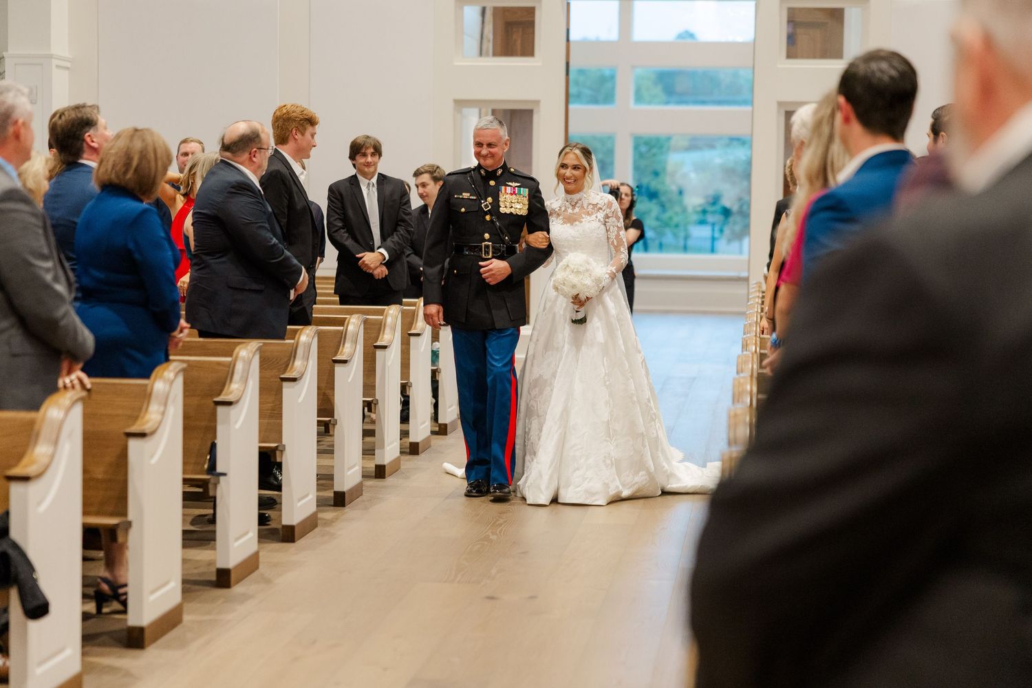 Wedding ceremony in a traditional church with guests seated in wooden pews.
