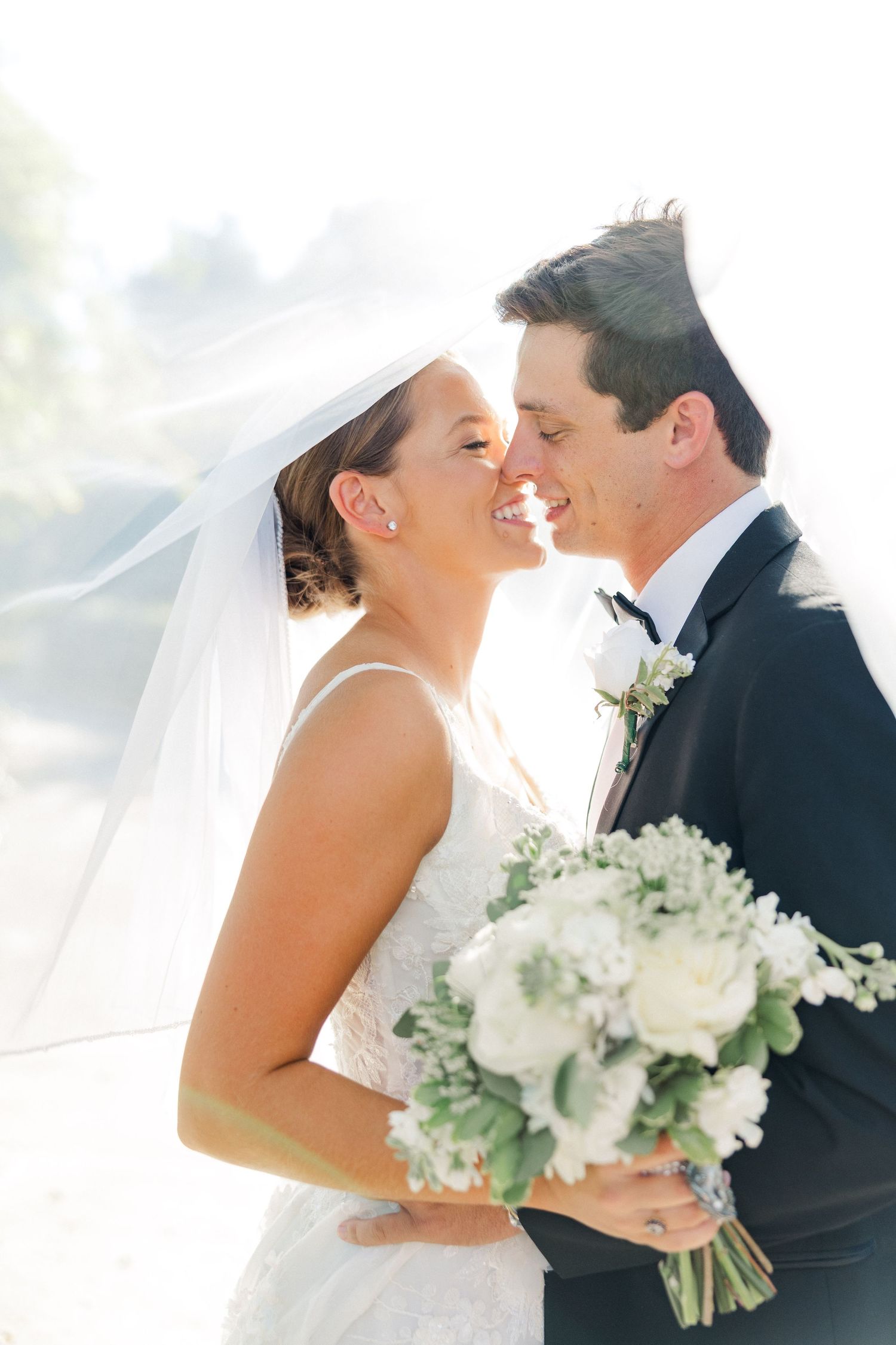 Intimate wedding portraits showing tender moments between newlyweds with white bouquet.