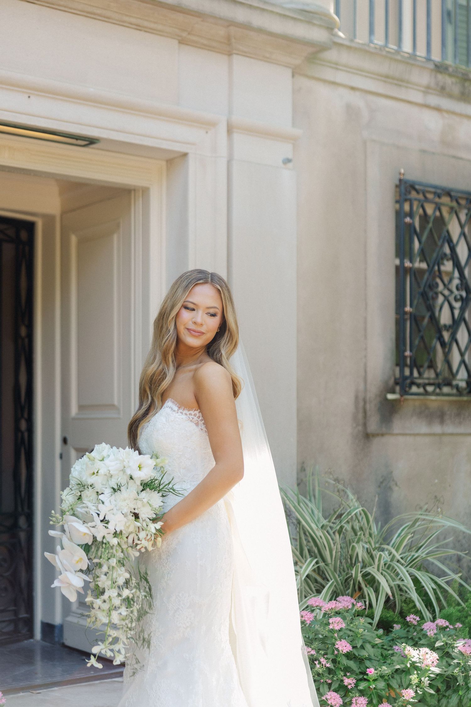 Elegant bridal portrait series featuring a white wedding dress and bouquet against a classic architectural backdrop.