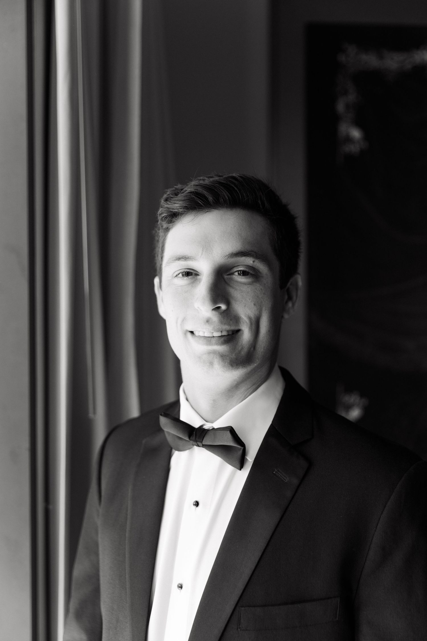 A series of formal portraits showing a groom in a black tuxedo and bow tie against a dark background.